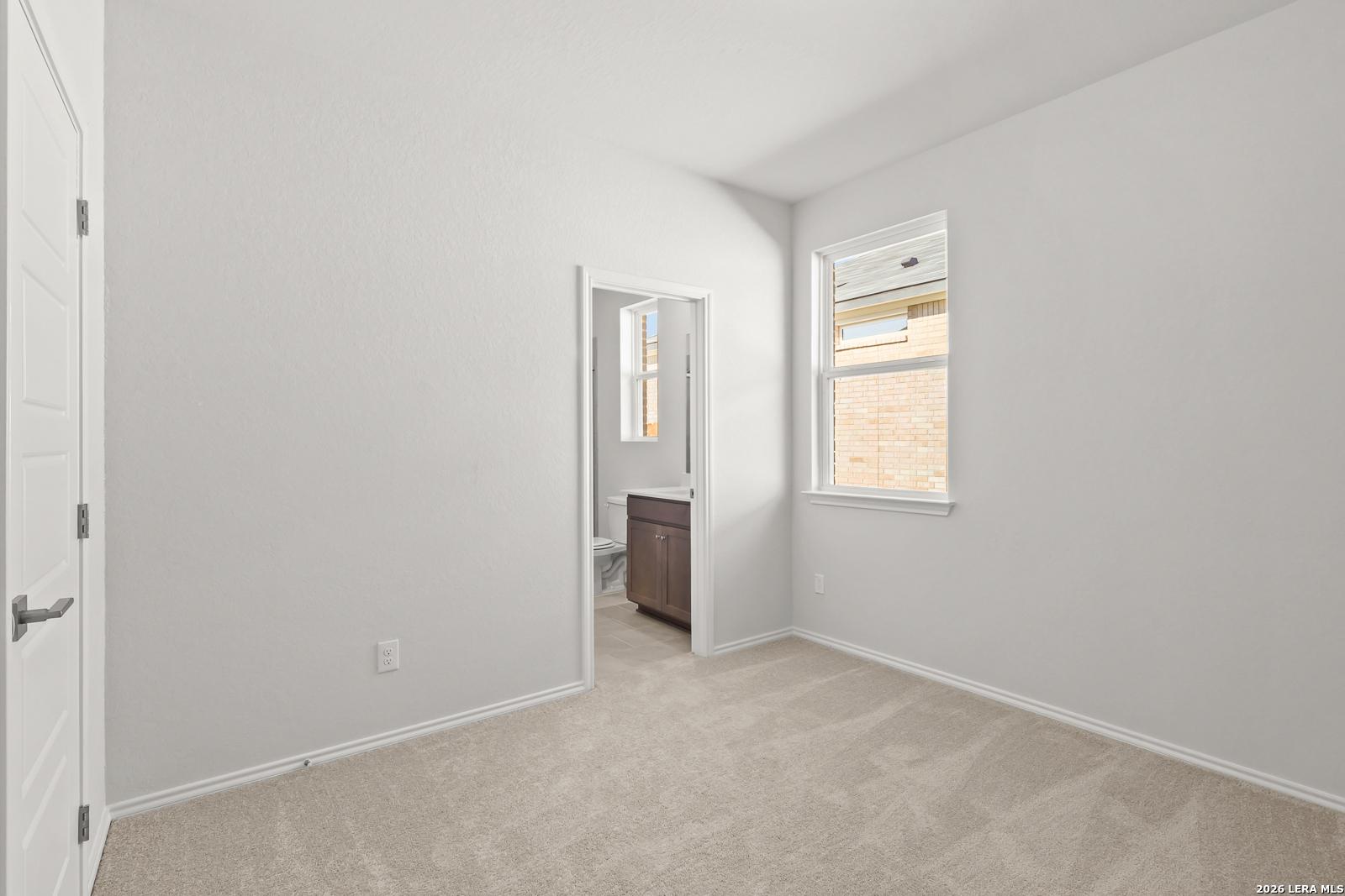 Bright carpeted bedroom with natural light and private bath access in Davidson Homes The Daphne I, Bricewood, San Antonio, Texas