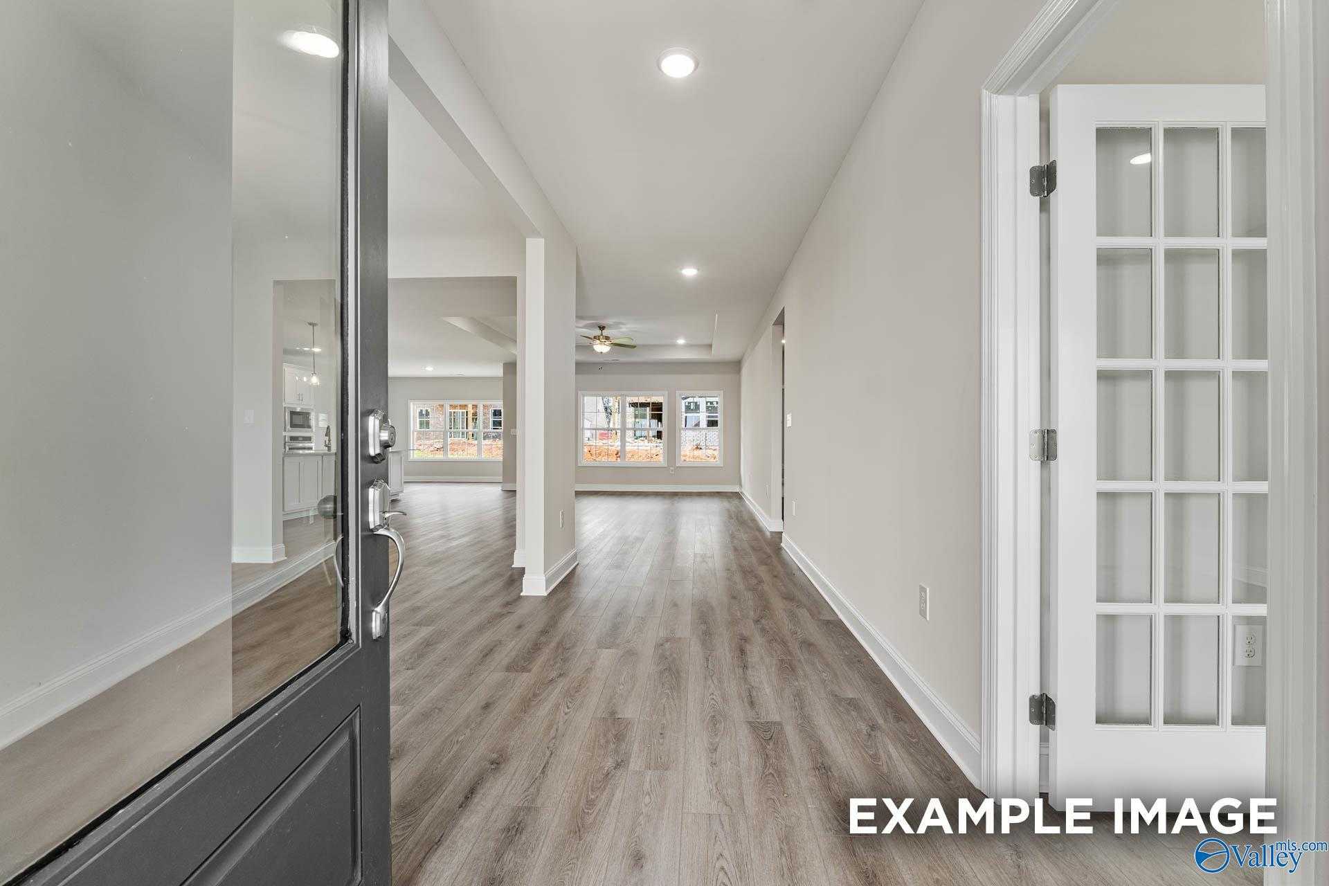 Bright entryway with glass front door, light wood floors, recessed lights, and large windows in Davidson Homes The Finleigh, Meridianville, Alabama