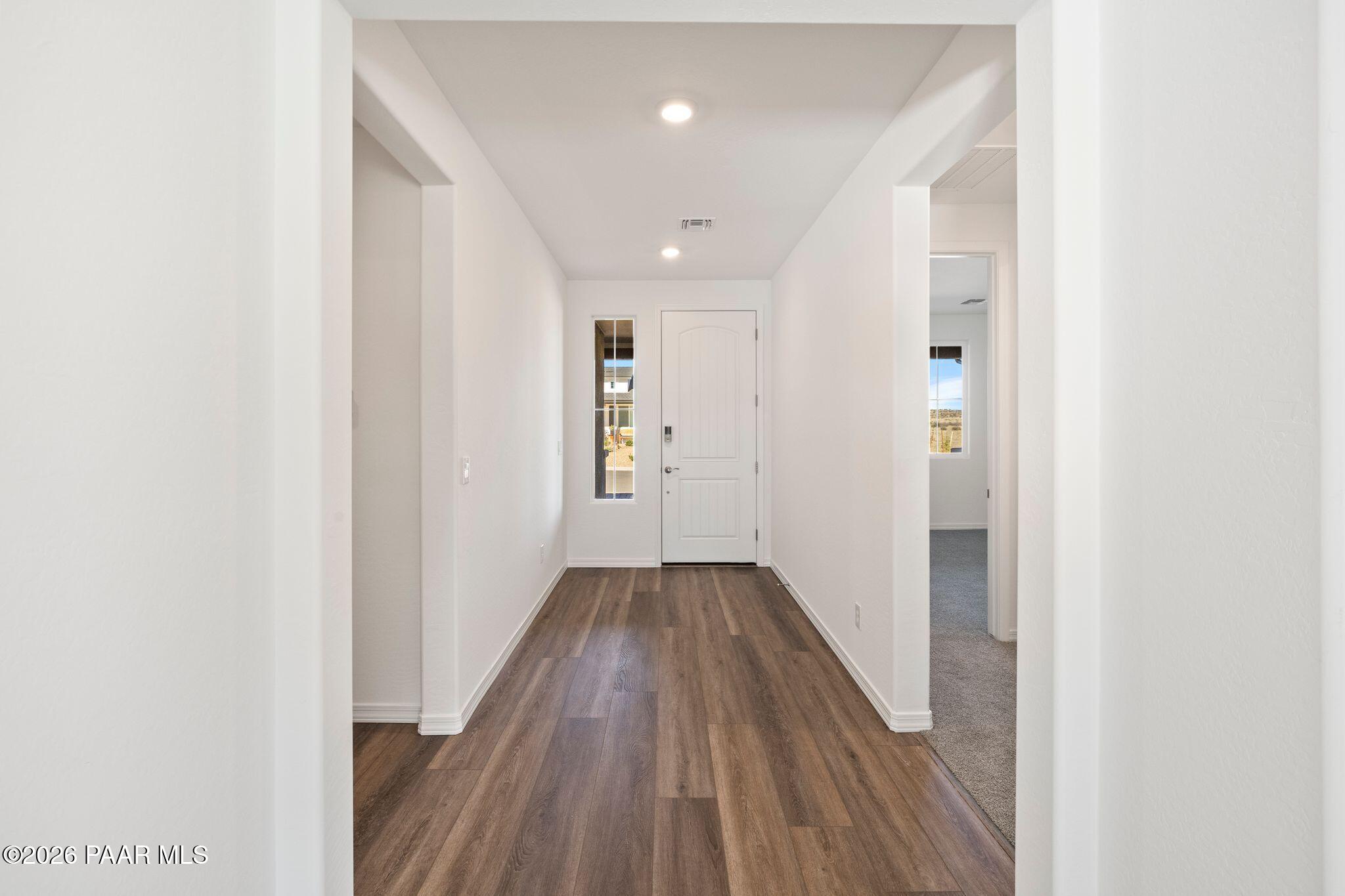 Elegant hallway with arched doorways, hardwood floors, and recessed lighting in Davidson Homes The Sunrise II A, Prescott, AZ