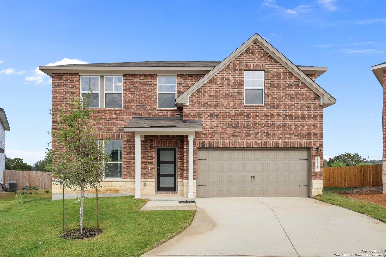 Two-story brick home with 2-car garage, covered entry, and front lawn in Royal Crest, San Antonio, TX - Davidson Homes The Murray J