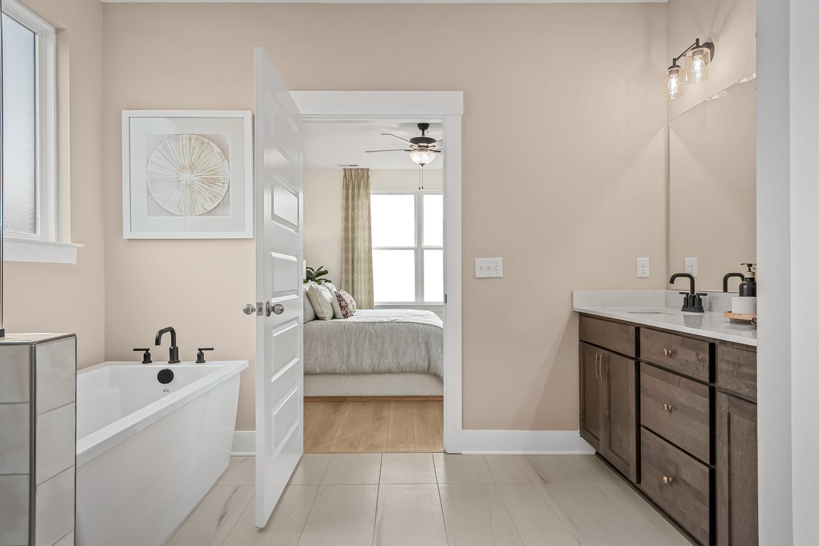 Spacious primary bathroom at Benders Cove in Mt. Juliet TN with freestanding soaking tub, double vanity, and open bedroom view