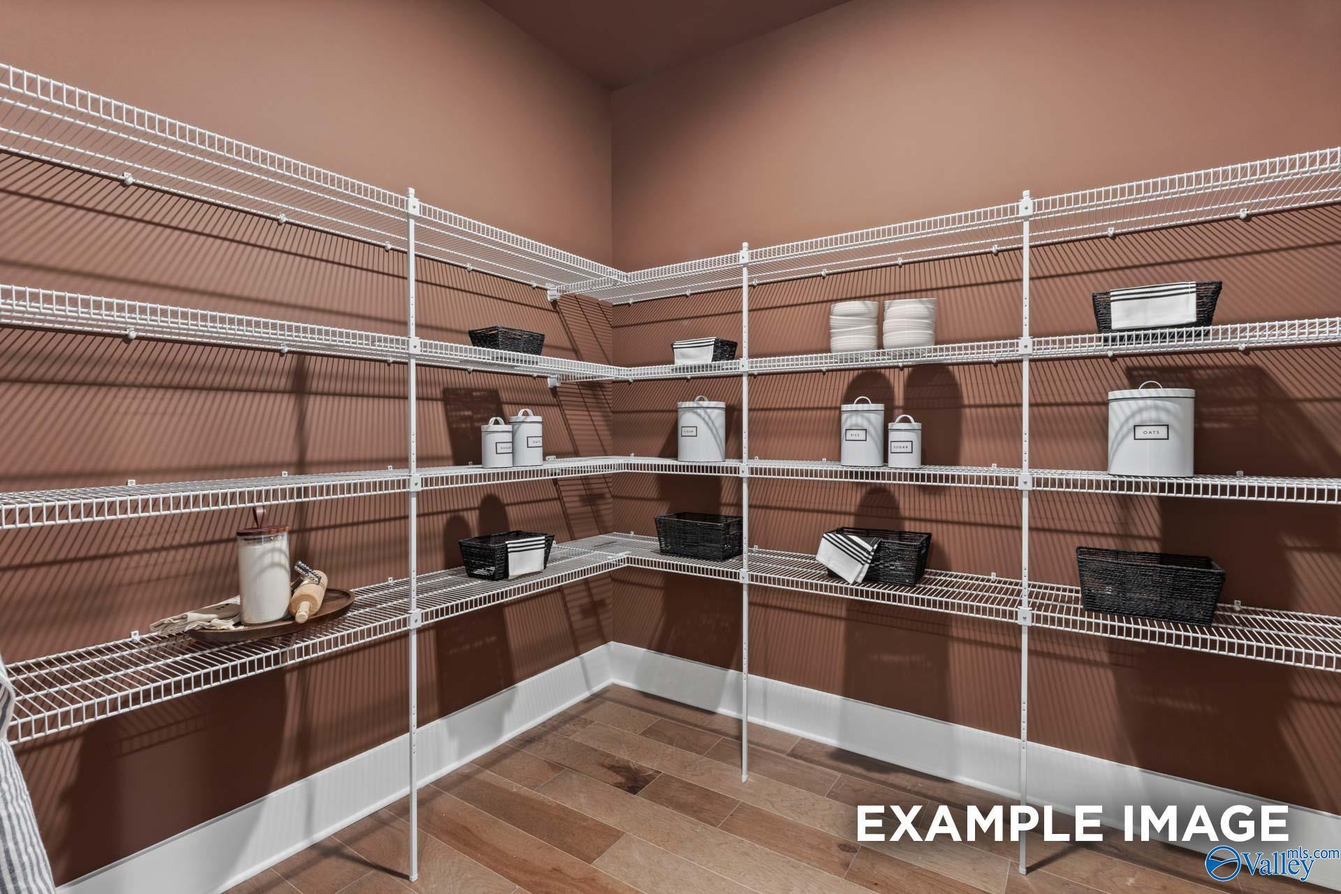 Organized corner pantry with white wire shelving, ceramic canisters, and baskets in Davidson Homes The Finleigh, Huntsville, AL