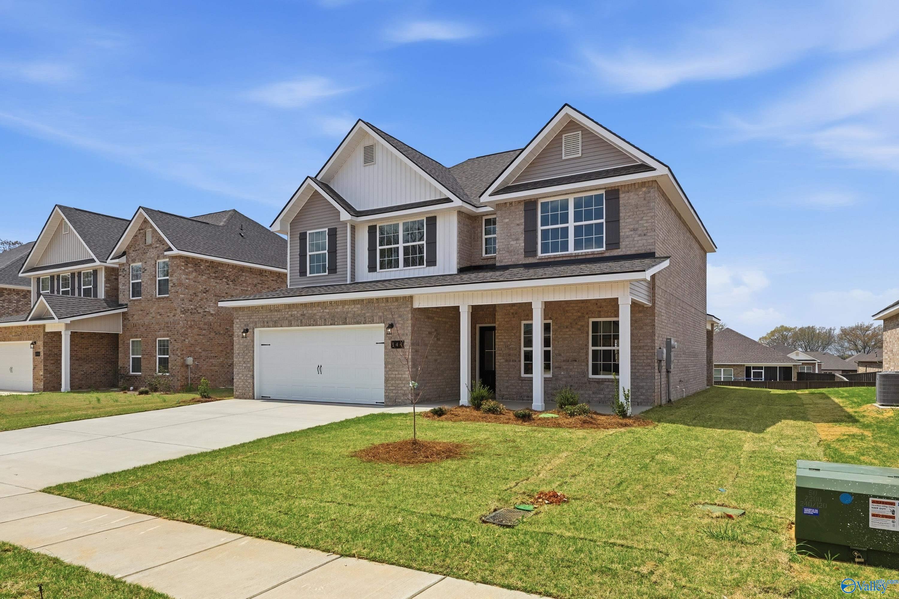 Two-story brick home with 2-car garage, columned front porch, and lush green yard in Creek Grove, New Market, Alabama - Davidson Homes Shelby B