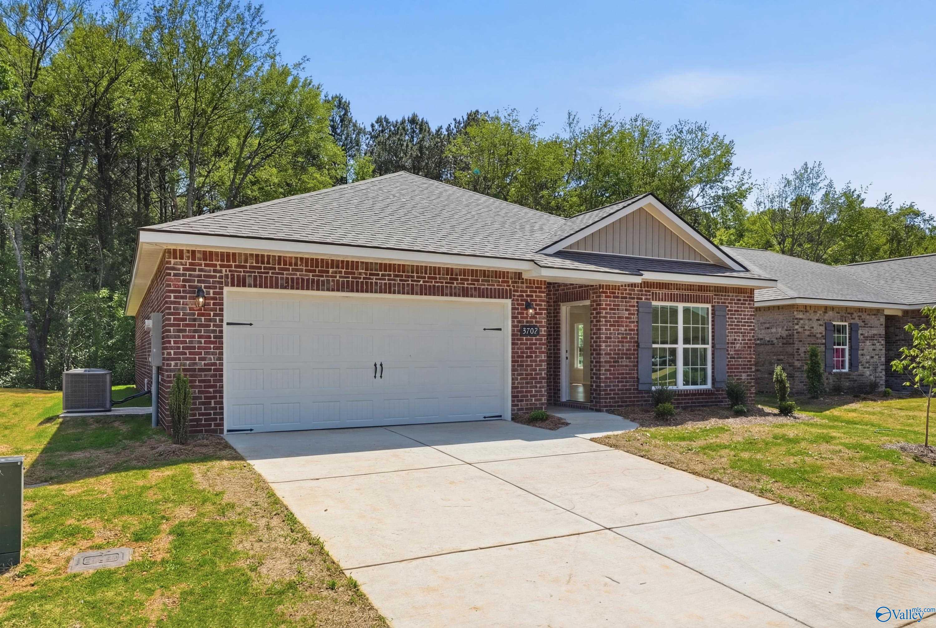 Brick single-story home with 2-car garage, driveway, and lush yard in Jaguar Hills, Huntsville, Alabama - Davidson Homes The Franklin