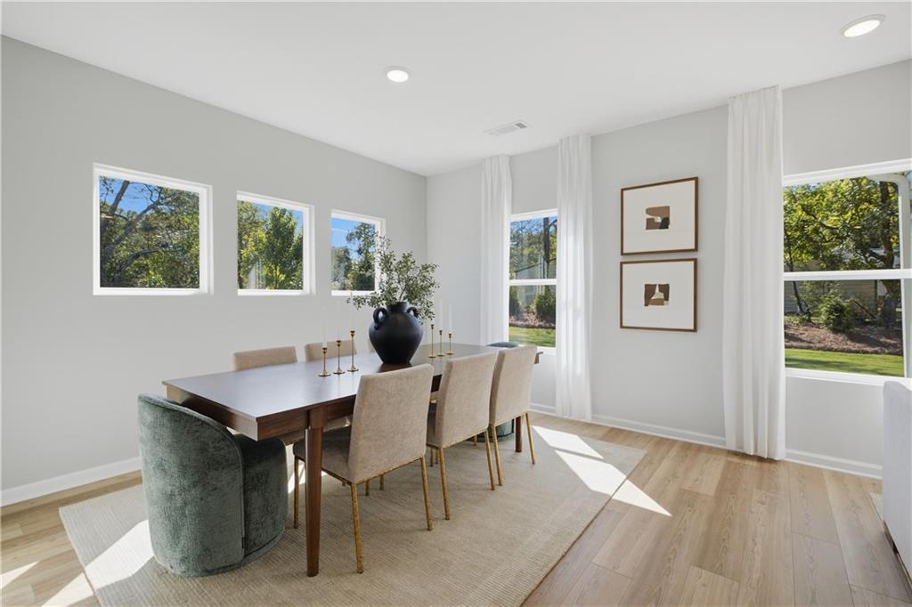 Bright dining room with wood floors, upholstered chairs, and natural light in Davidson Homes The Sinclair B, Cartersville, GA