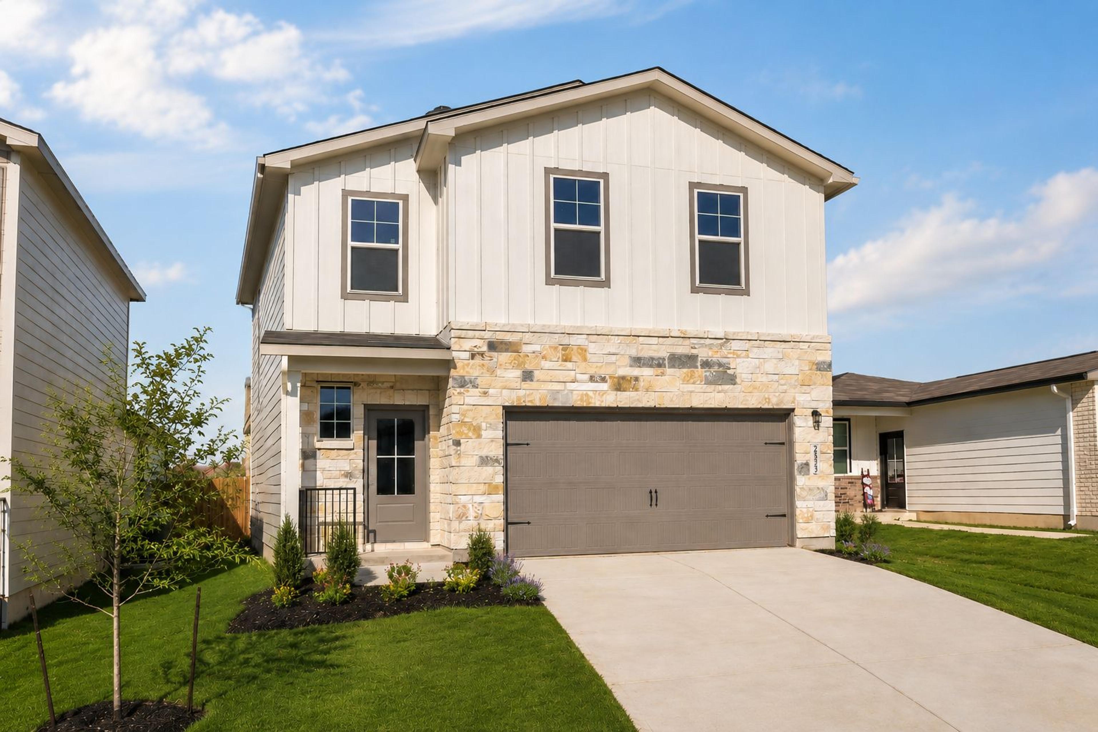 Two-story Davidson Homes exterior at Applewhite Meadows in San Antonio, TX, featuring stone accents and a two-car garage.
