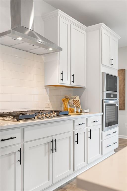 Modern kitchen with white cabinets, stainless steel appliances, and gas cooktop in The Rabun B plan at The Bluffs, Canton.