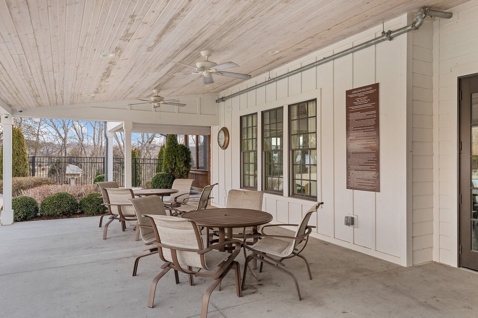 Covered back patio with wooden ceiling, ceiling fans, wicker seating, and pool view in Davidson Homes The Ridgeport, Gallatin, TN