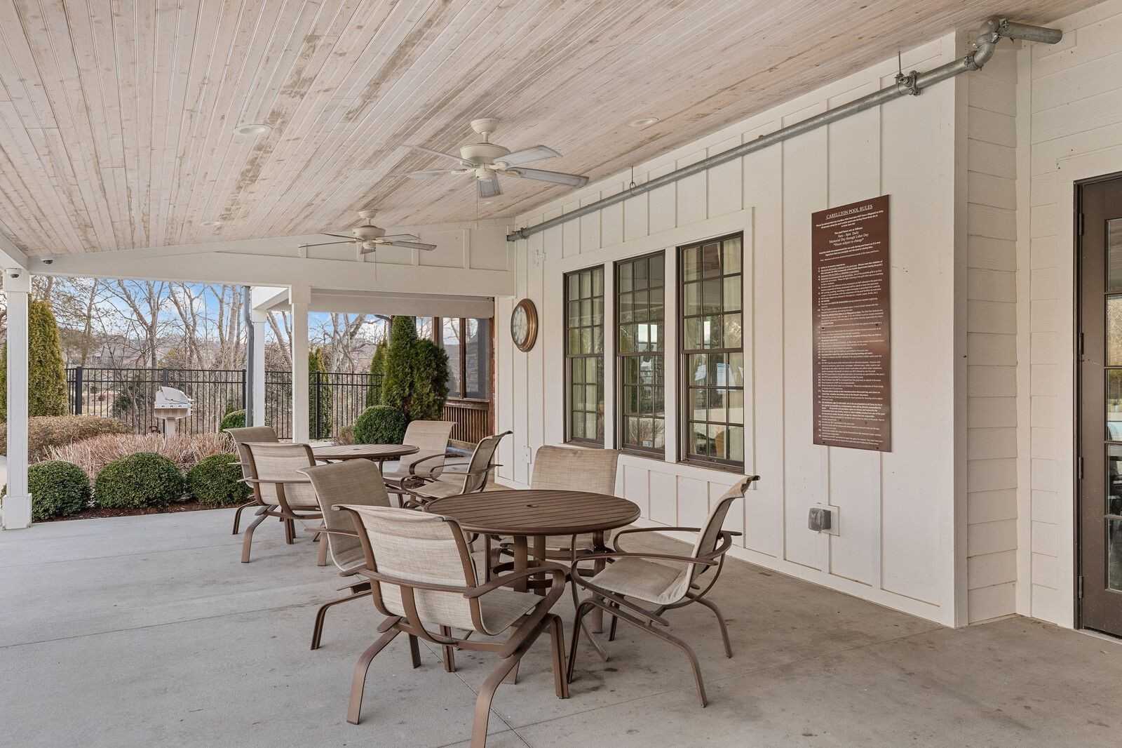 Covered back patio with wooden ceiling, ceiling fans, wicker seating, and pool view in Davidson Homes The Ridgeport, Gallatin, TN