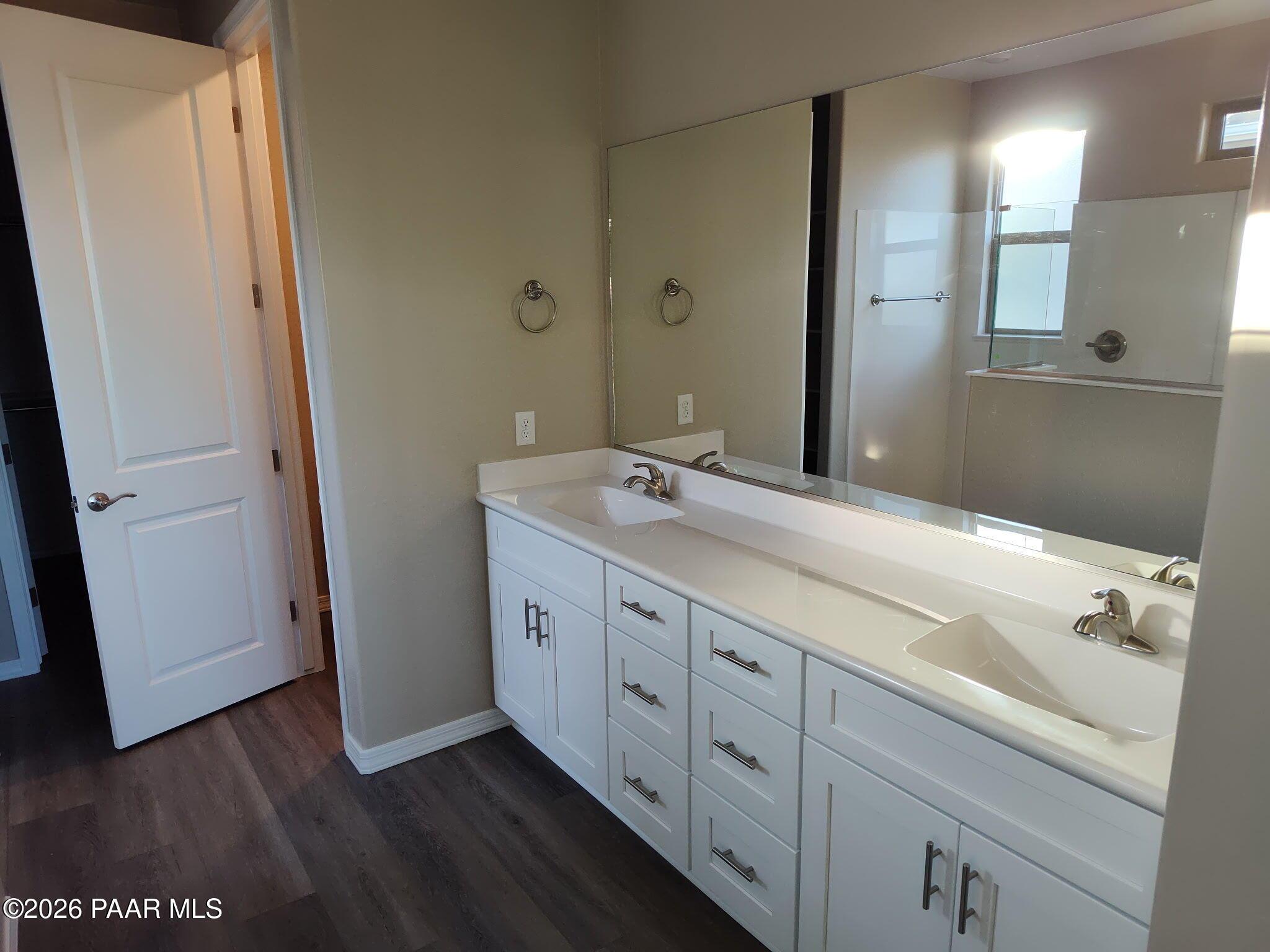 Double vanity bathroom with white cabinets and large mirror in The Inspiration C home at North Ridge, Prescott Valley.