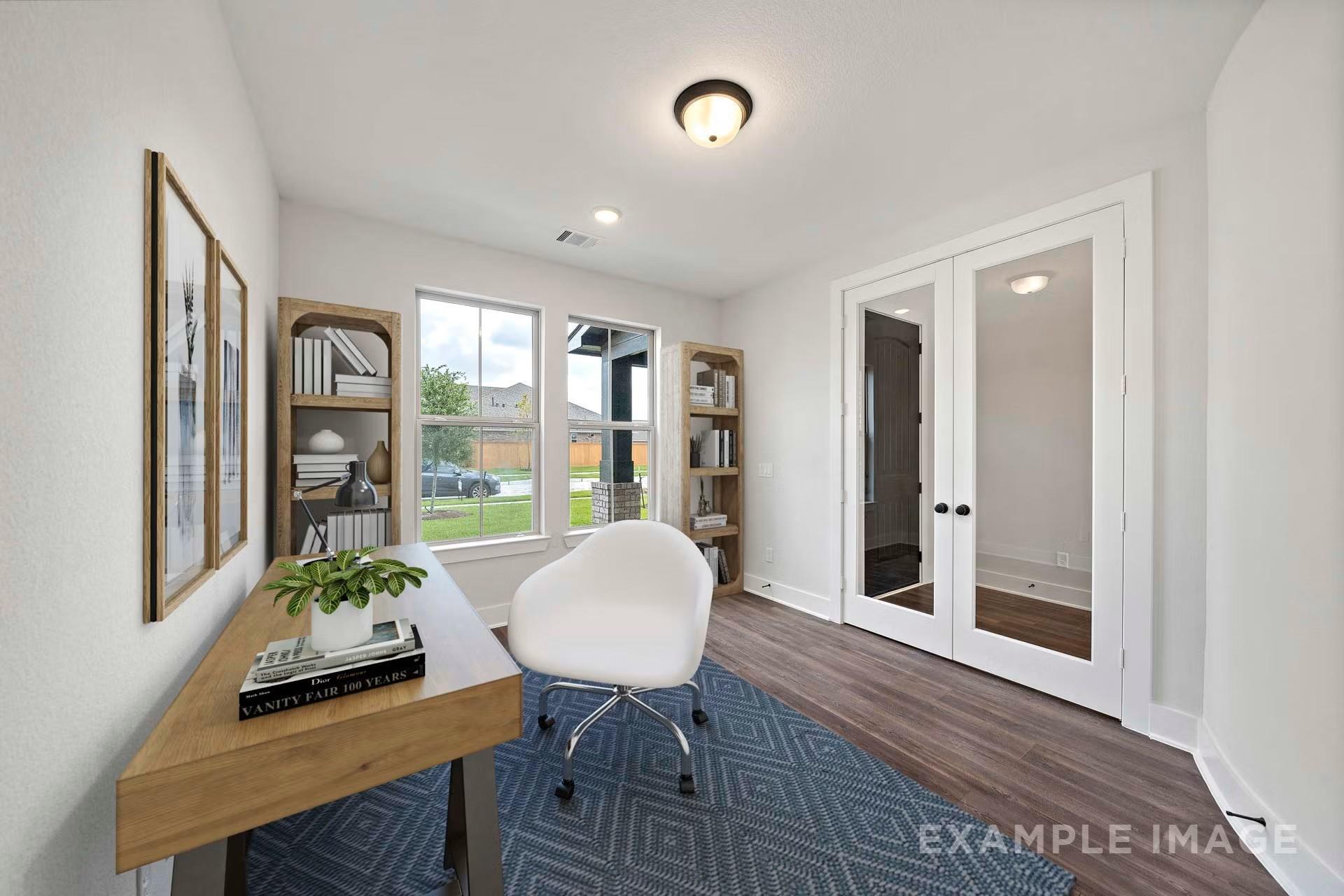 Bright home office with wooden desk, white swivel chair, bookshelves, and French doors in Davidson Homes The Victoria A, Lago Mar, Texas