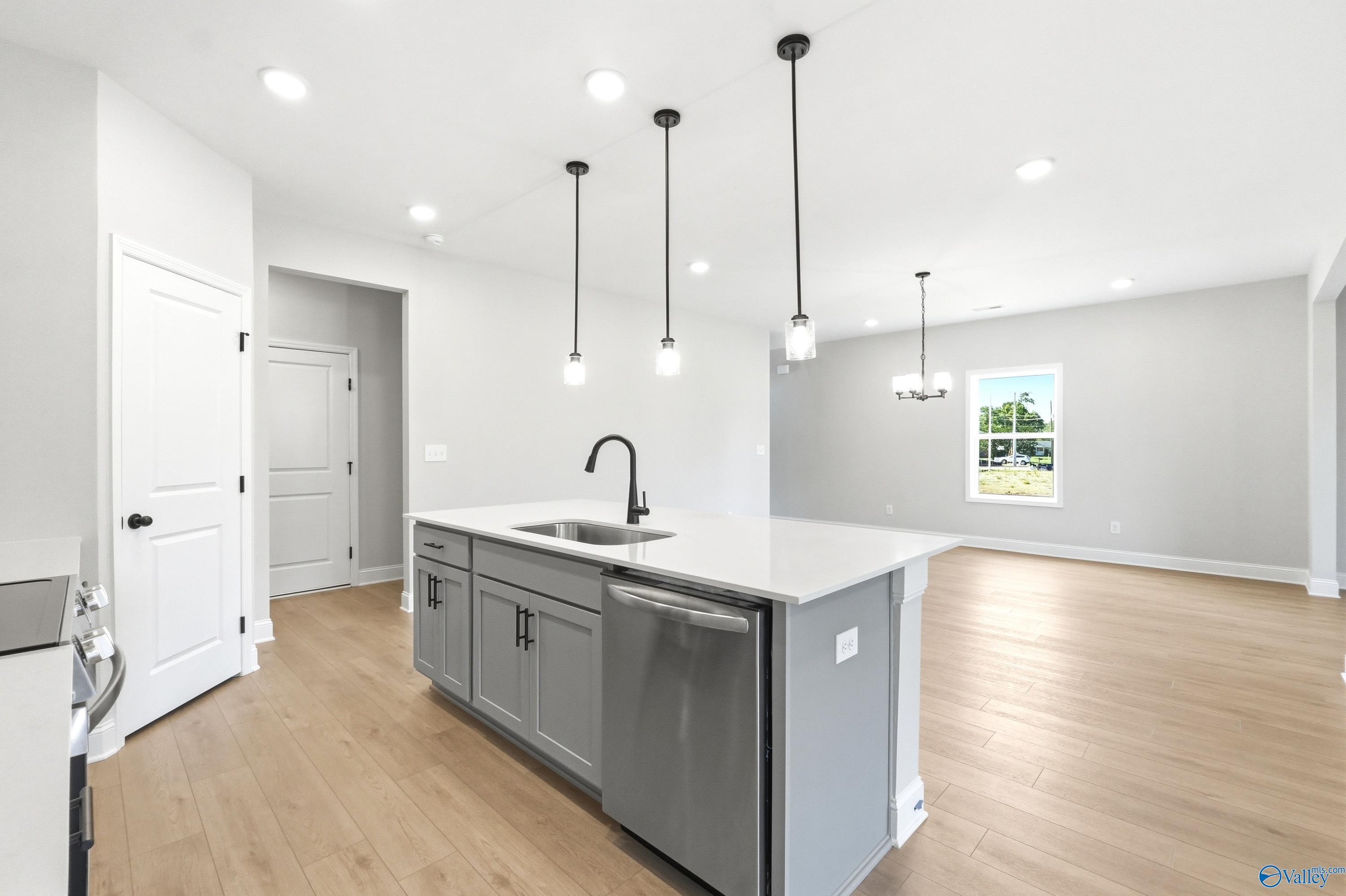 Modern kitchen island with gray cabinetry and pendant lighting in The Russell A floor plan, Spragins Cove, Huntsville.