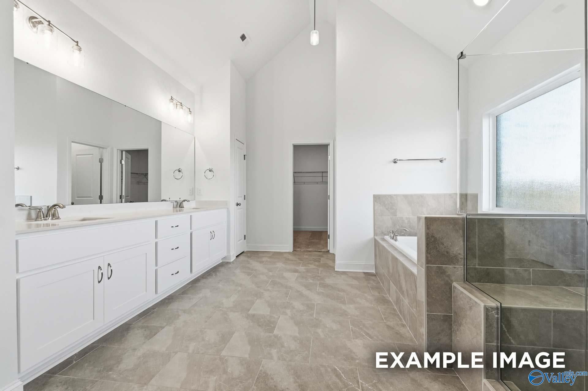 Modern primary bathroom with double vanity, soaking tub, and walk-in shower in The Valencia floor plan, Briercreek.