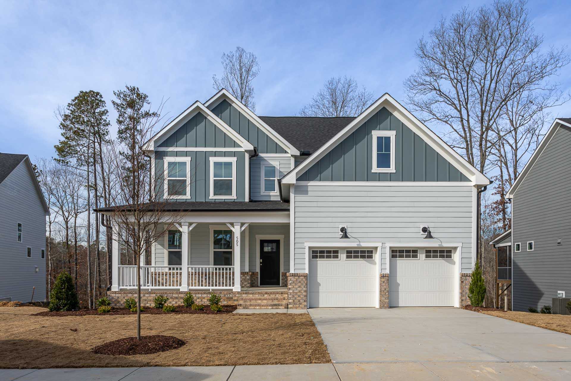 Contemporary two-story home exterior at Bentwinds in Fuquay-Varina NC with covered porch, two-car garage, and landscaped yard