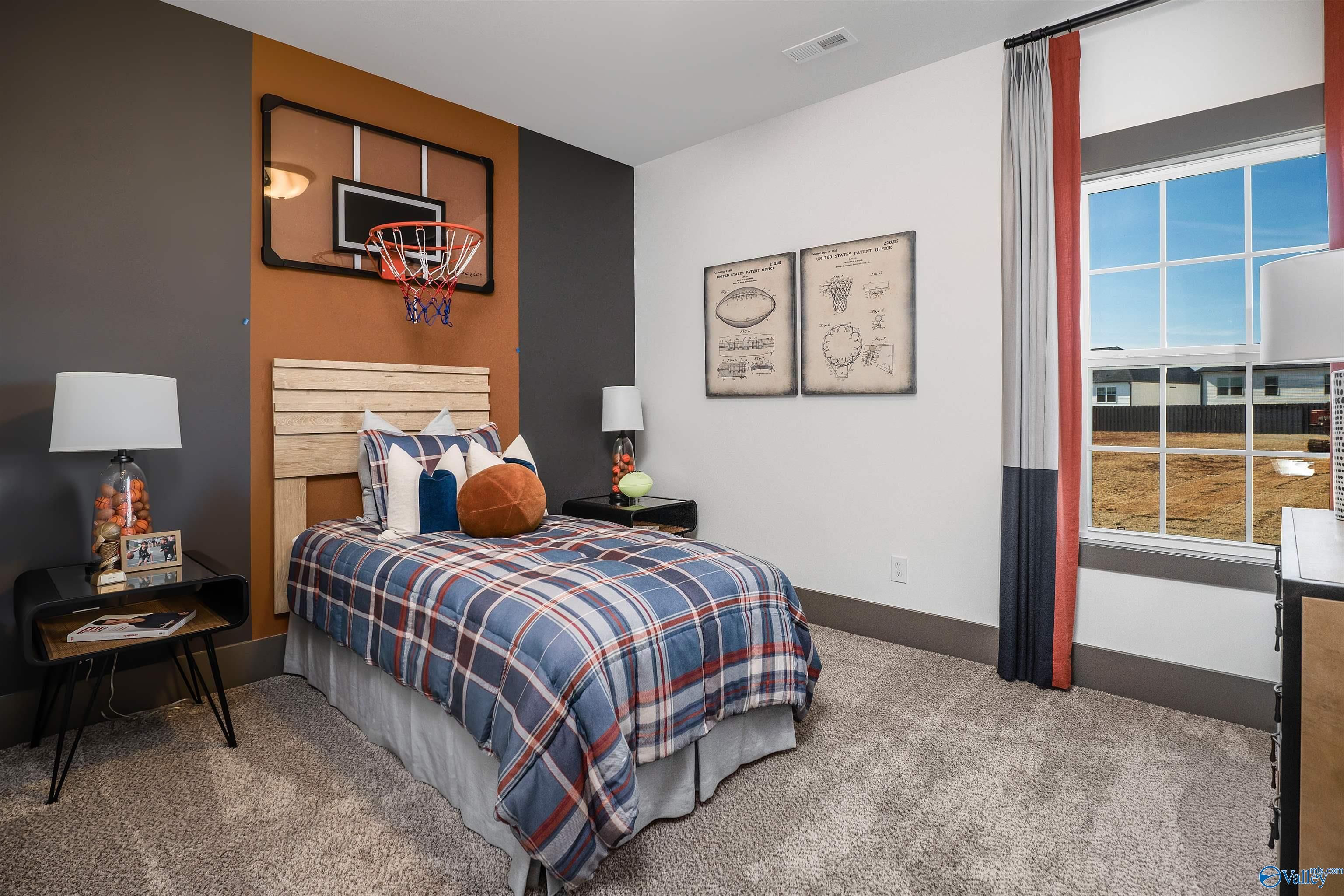 Boy's bedroom with basketball wall hoop, plaid bedding, and sports art in Davidson Homes The Rockford B, Madison, Alabama