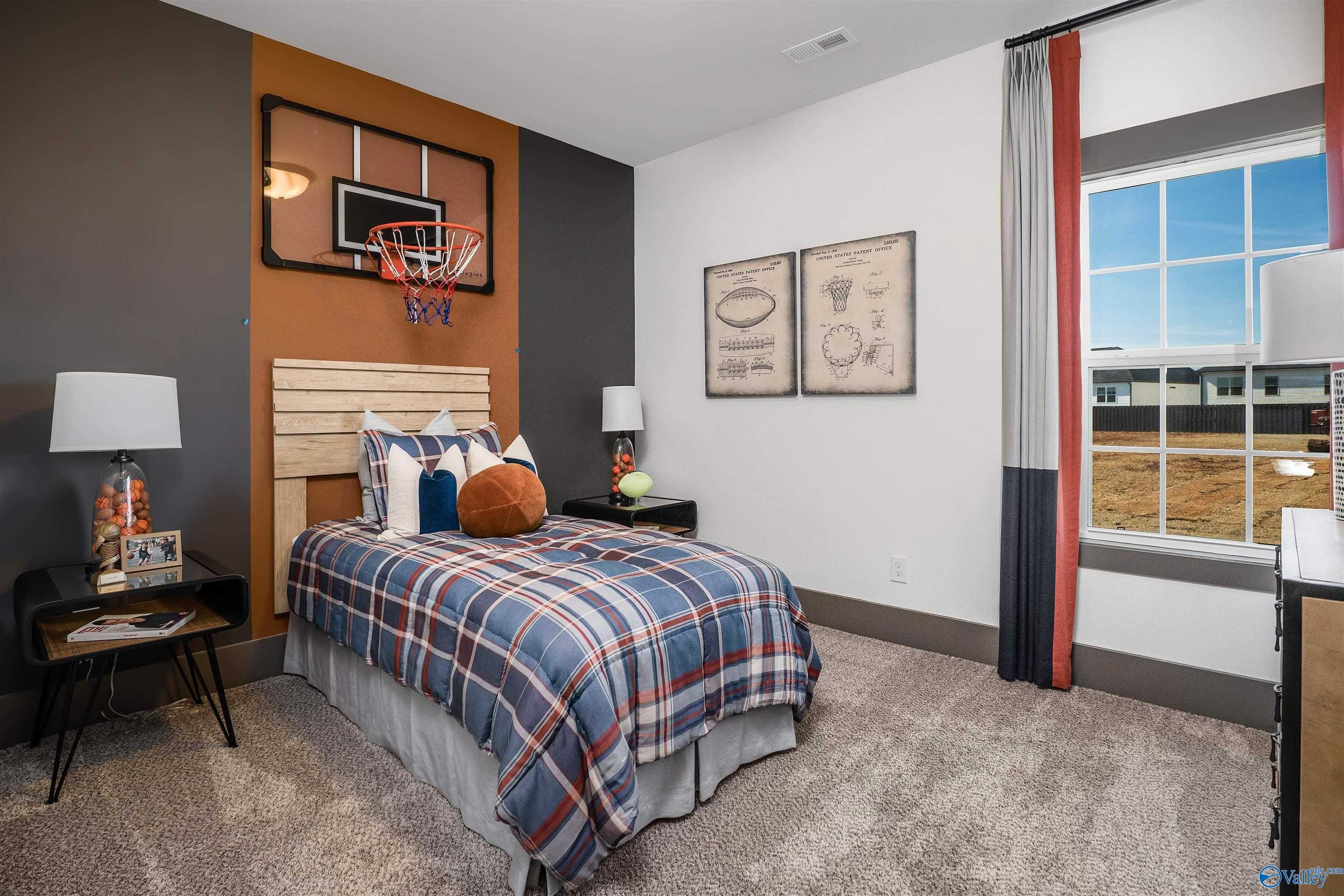 Boy's bedroom with basketball wall hoop, plaid bedding, and sports art in Davidson Homes The Rockford B, Madison, Alabama