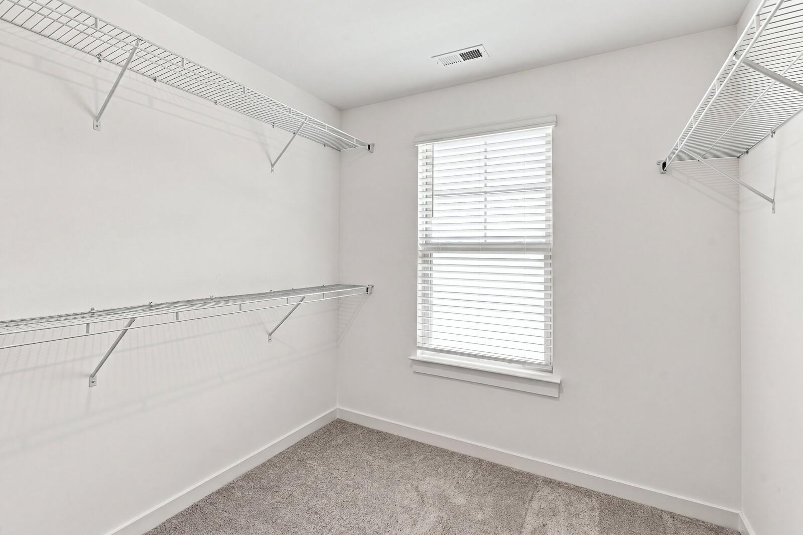 Spacious walk-in closet with wire shelving and natural light in Davidson Homes The Willow C plan, Gallatin, TN