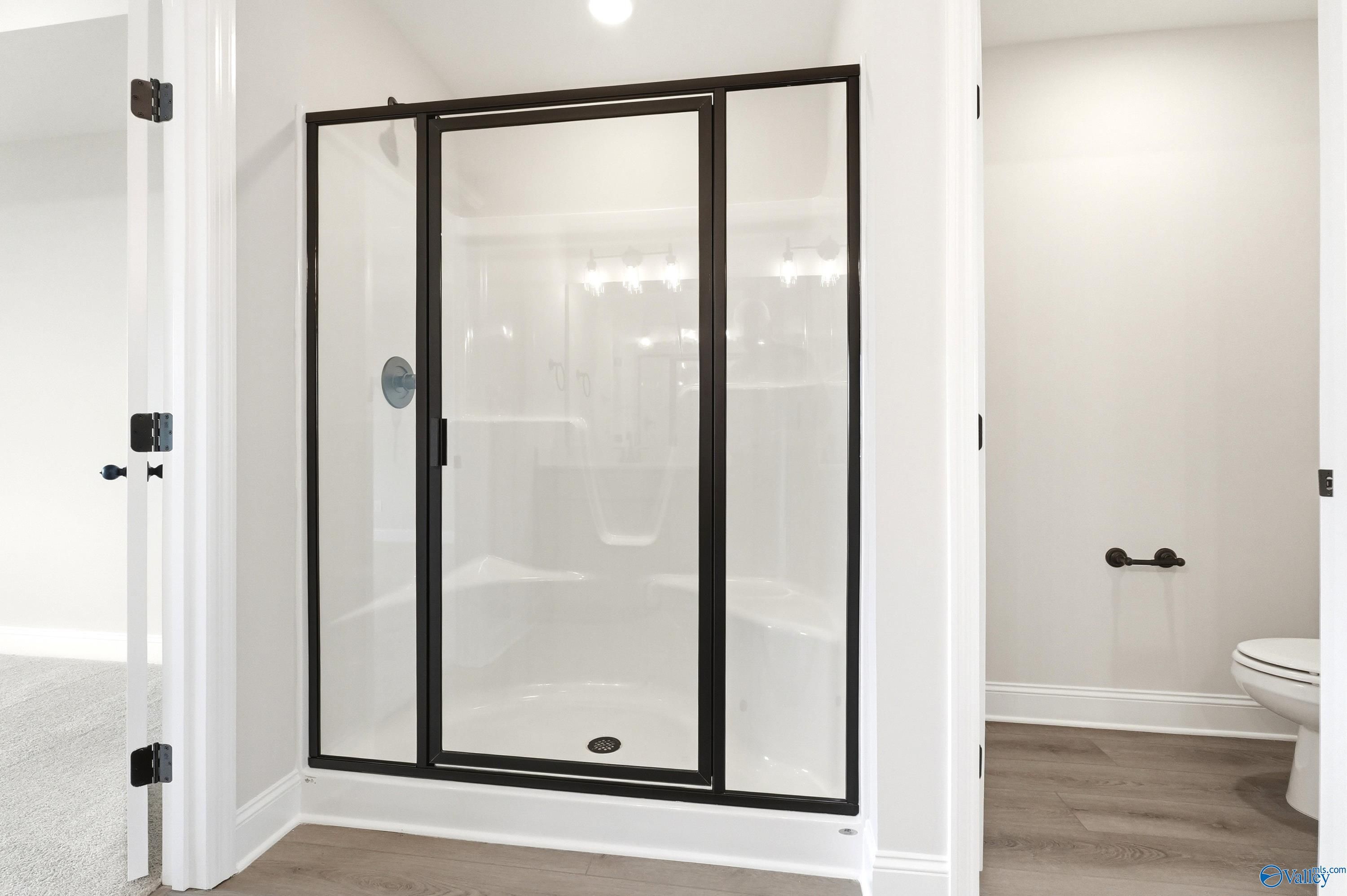Walk-in shower with black frame, built-in bench, and modern fixtures in The Shelby A floor plan, Clearview, Hazel Green.