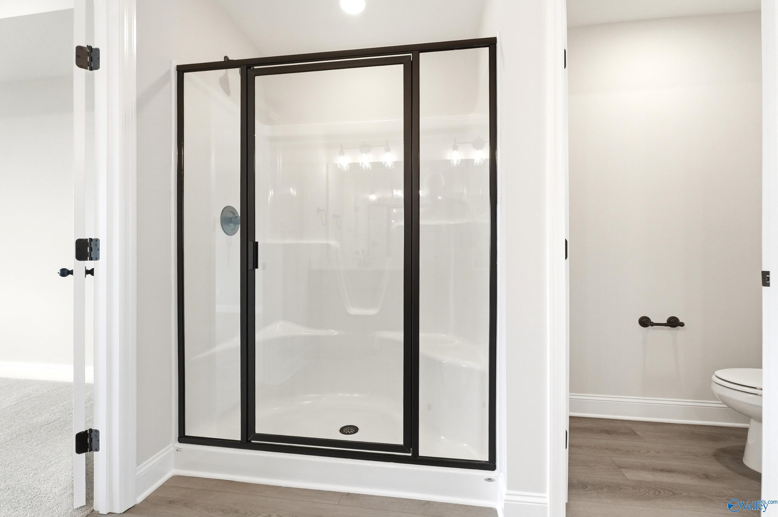Walk-in shower with black frame, built-in bench, and modern fixtures in The Shelby A floor plan, Clearview, Hazel Green.