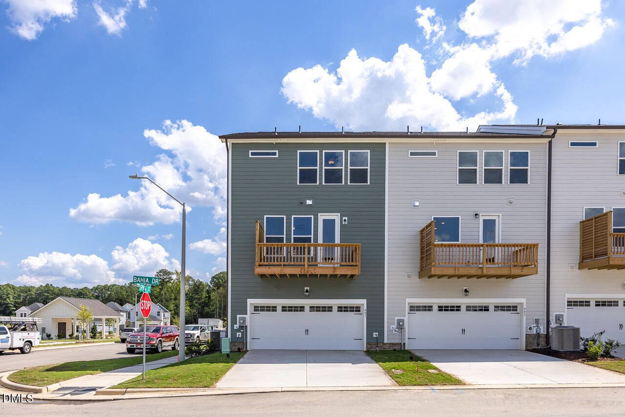 Three-story townhome exteriors with wooden balconies and 2-car garages at Forestville Yard Townhomes, Knightdale, North Carolina