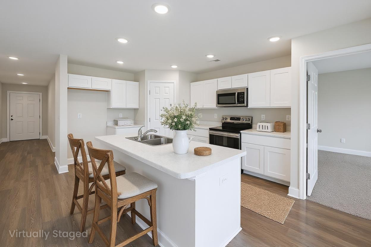 Bright white kitchen with central island, wooden bar stools, stainless steel appliances, and hardwood floors at Chapel Hill in Athens, Alabama