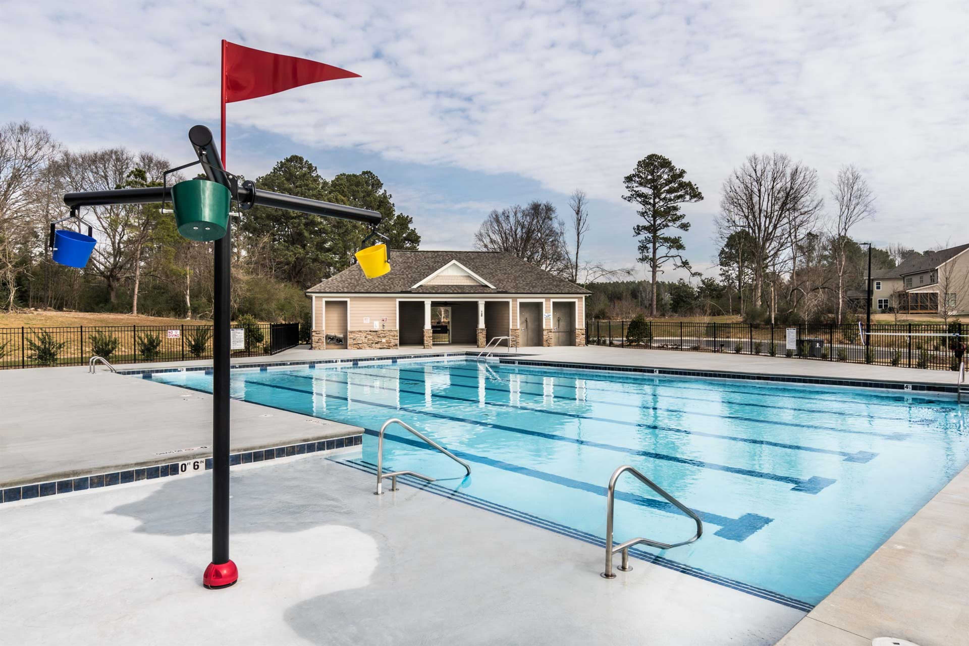 Community swimming pool at Glenmere in Knightdale NC with colorful bucket fountain, lap lanes, and cabana pool house
