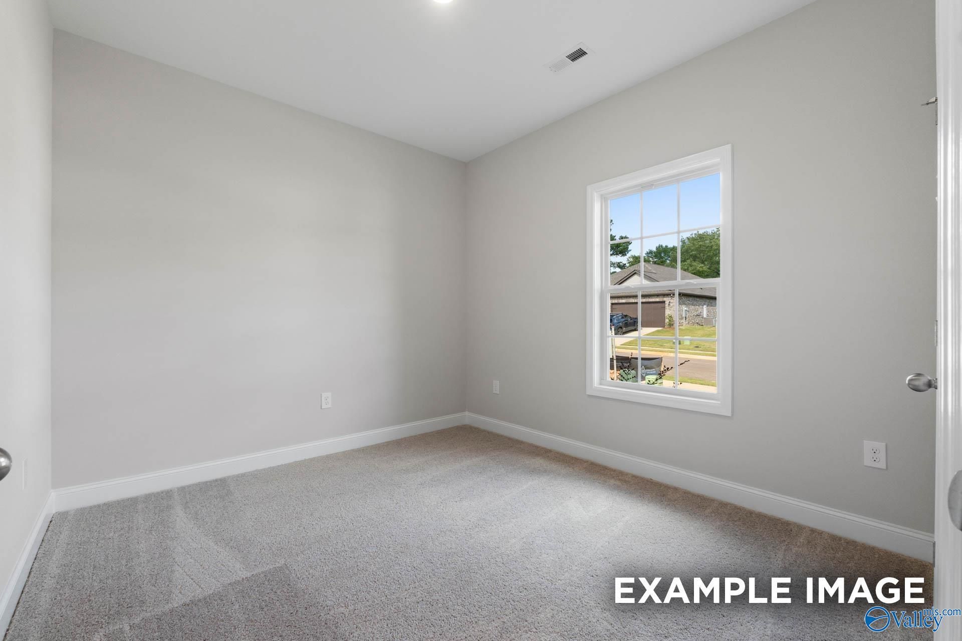 Bright secondary bedroom with gray walls, carpet flooring, and neighborhood view window in Davidson Homes The Butler, Huntsville, Alabama