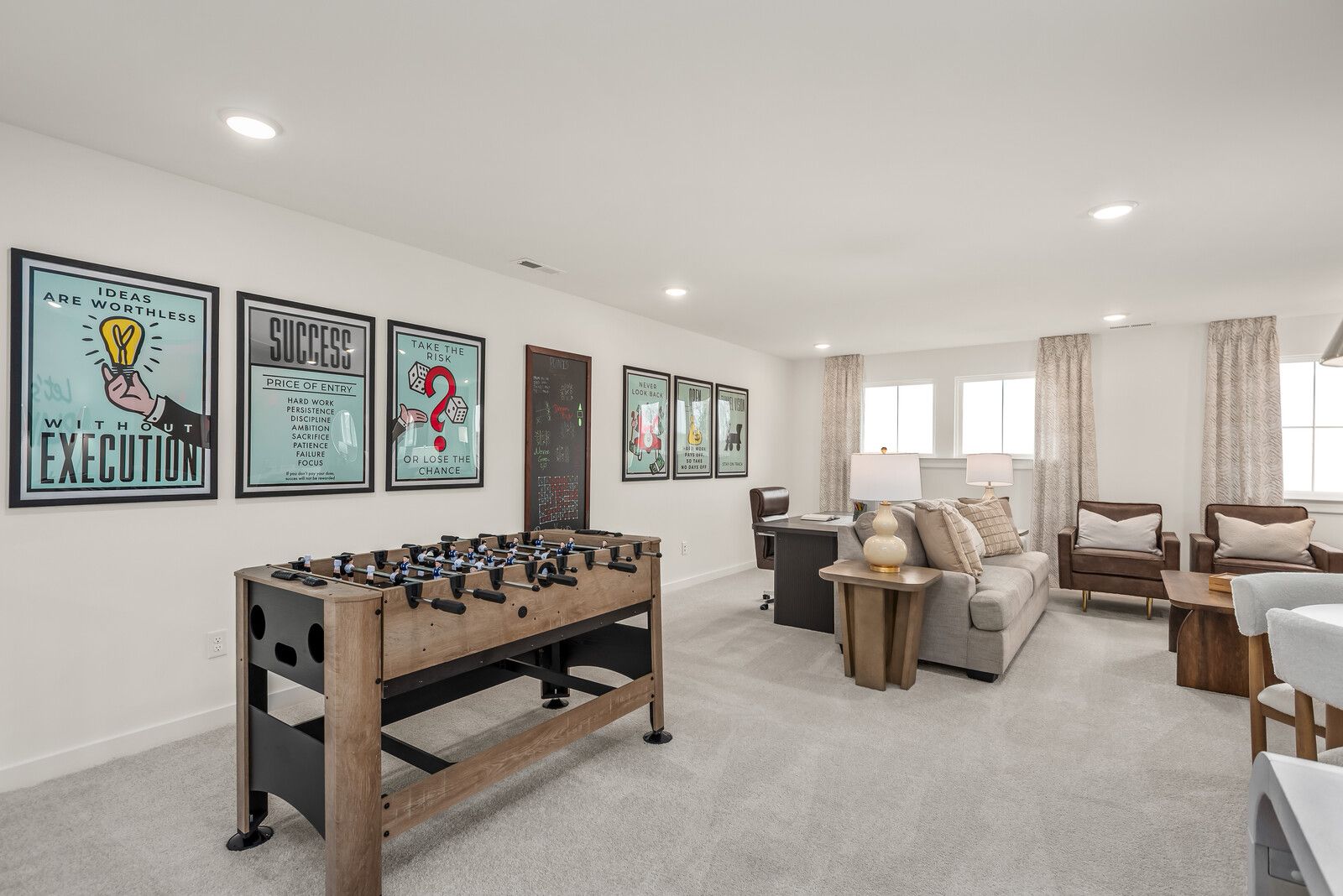 Spacious bonus room at Benders Cove in Mt. Juliet TN with foosball table, motivational wall art, and plush seating