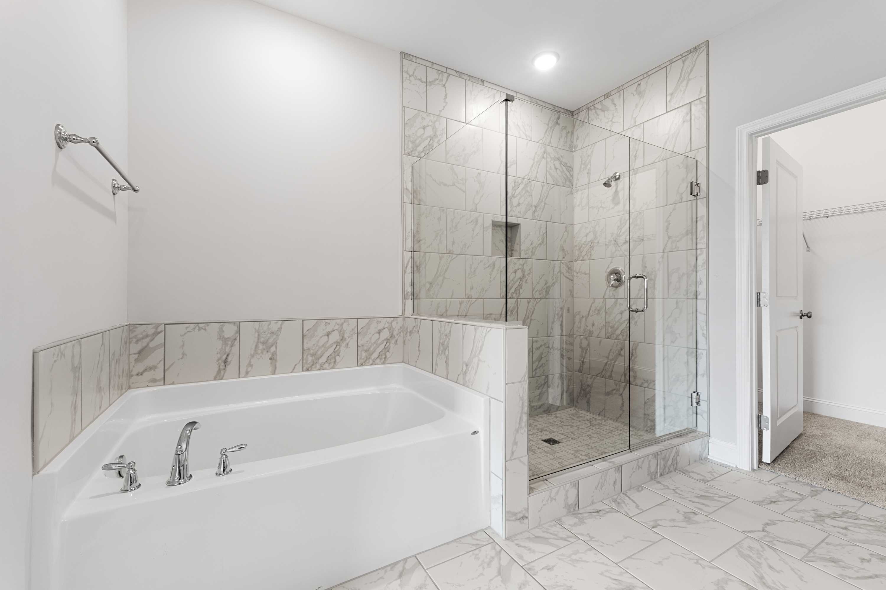 Modern master bathroom in The Copeland B featuring corner soaking tub and glass walk-in shower