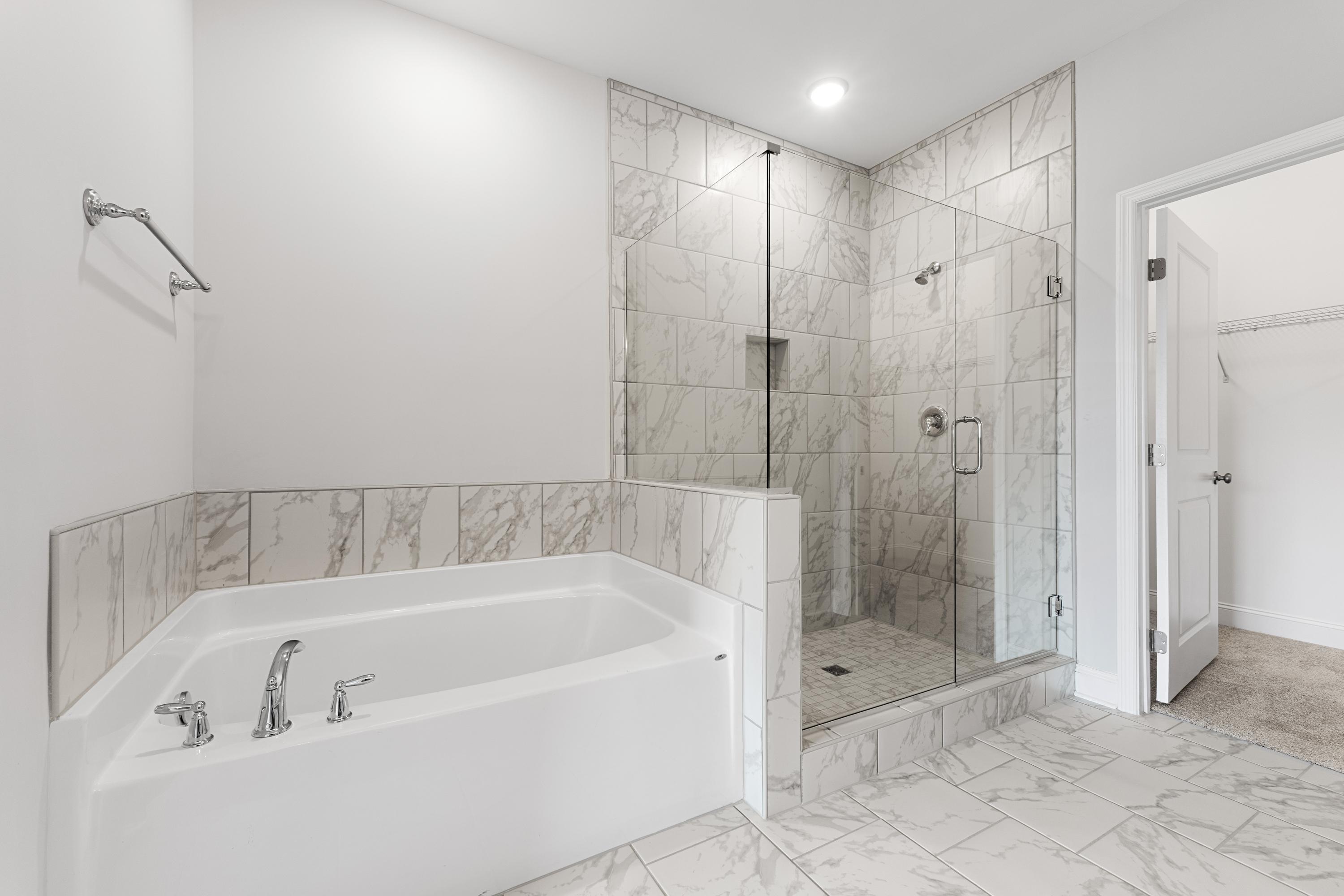 Modern master bathroom in The Copeland B featuring corner soaking tub and glass walk-in shower