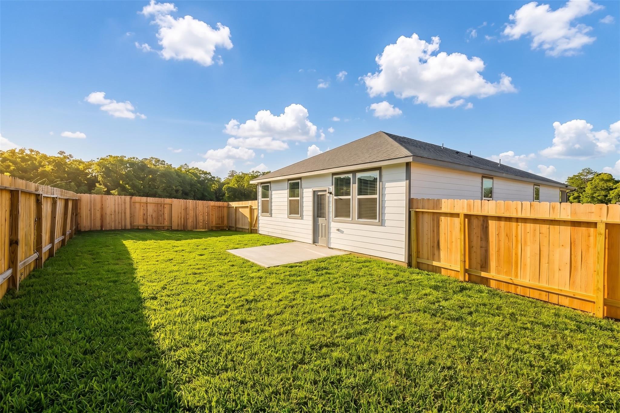 Private backyard with concrete patio and wood fencing at a Davidson Homes 4-bedroom house in Liberty Estates, Cleveland, TX.