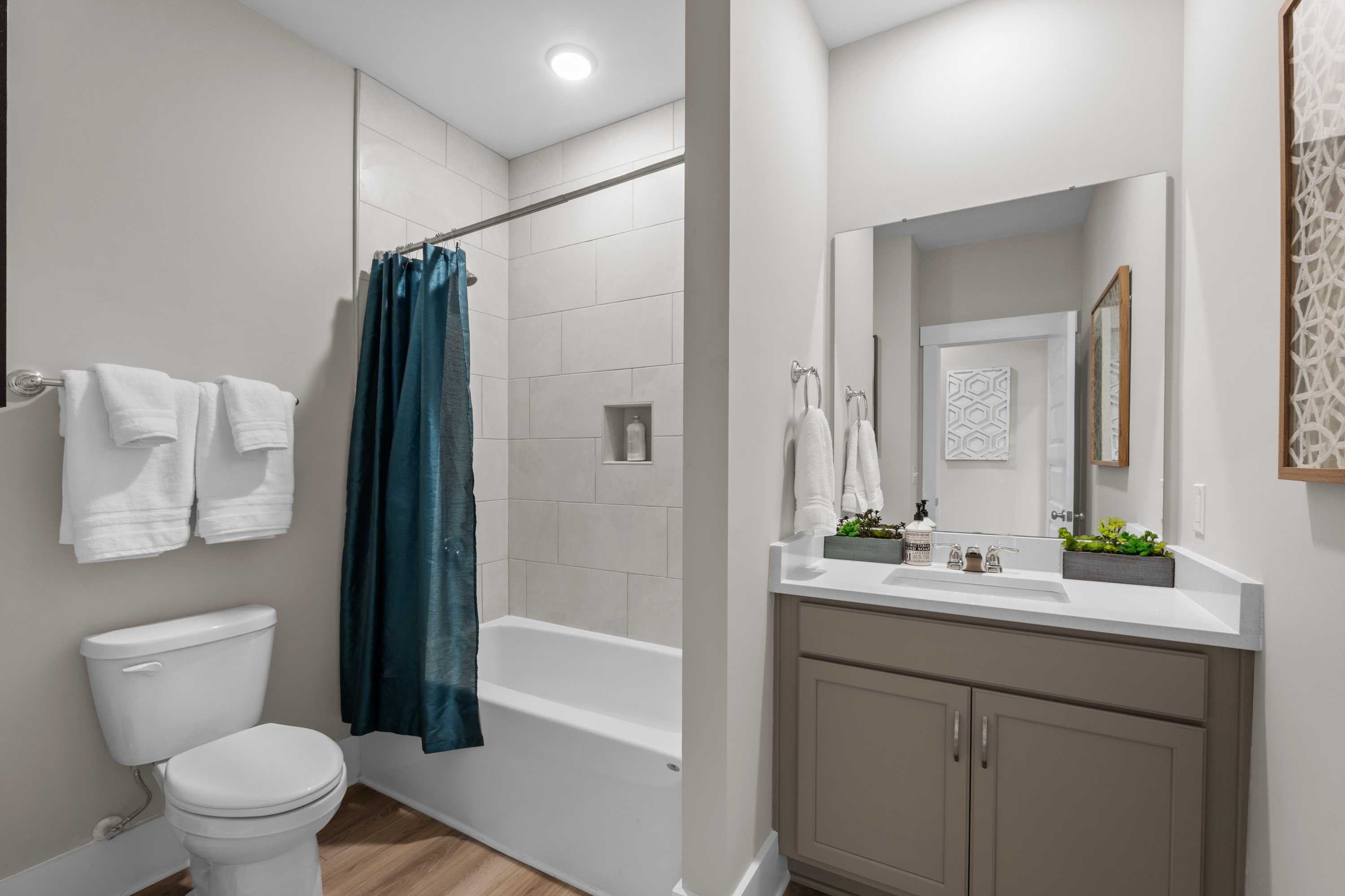 Modern bathroom at The Highlands in Arab AL featuring tub-shower combo, walk-in shower, vanity sink, and wood floors