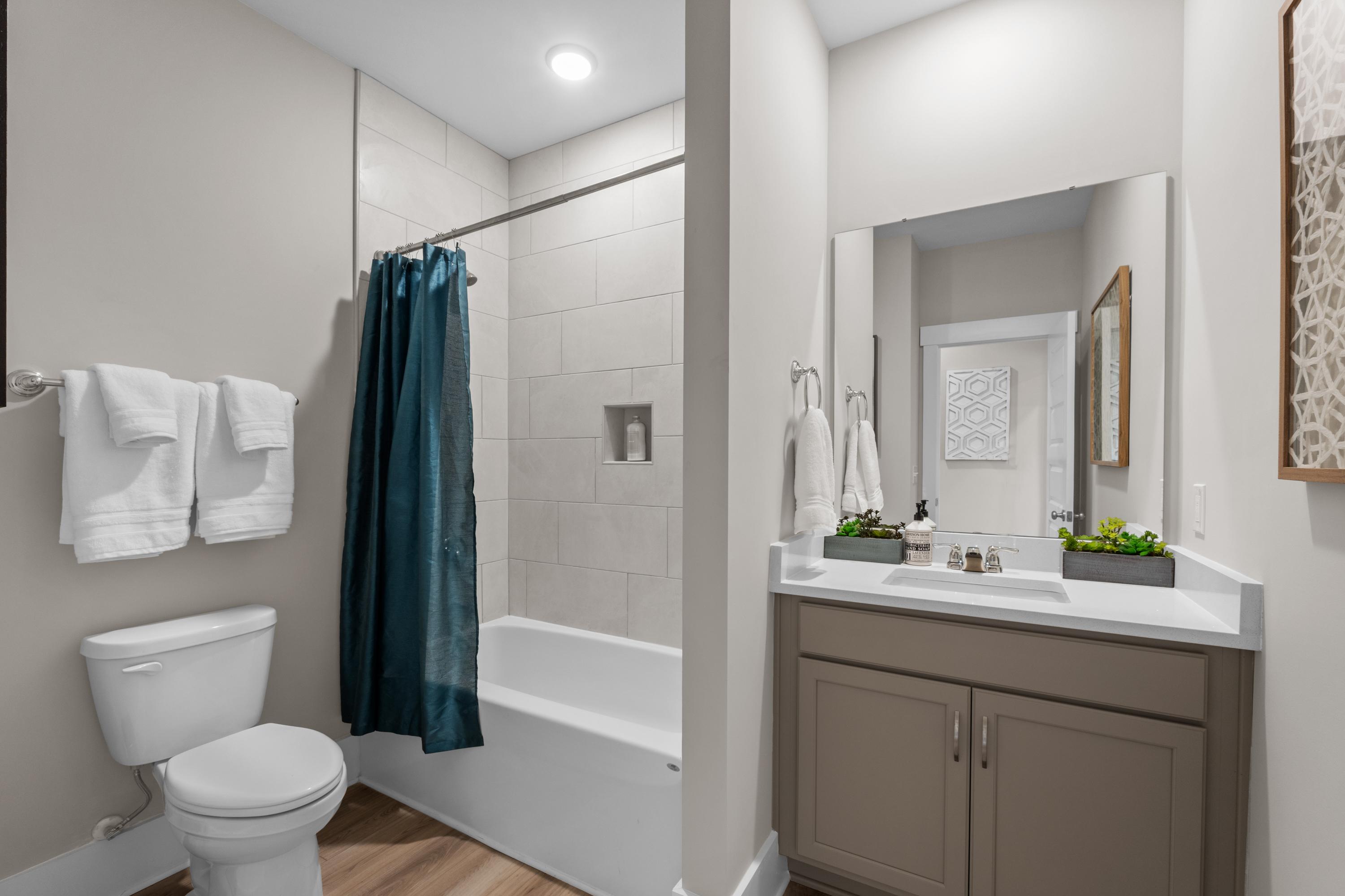 Modern bathroom at The Highlands in Arab AL featuring tub-shower combo, walk-in shower, vanity sink, and wood floors
