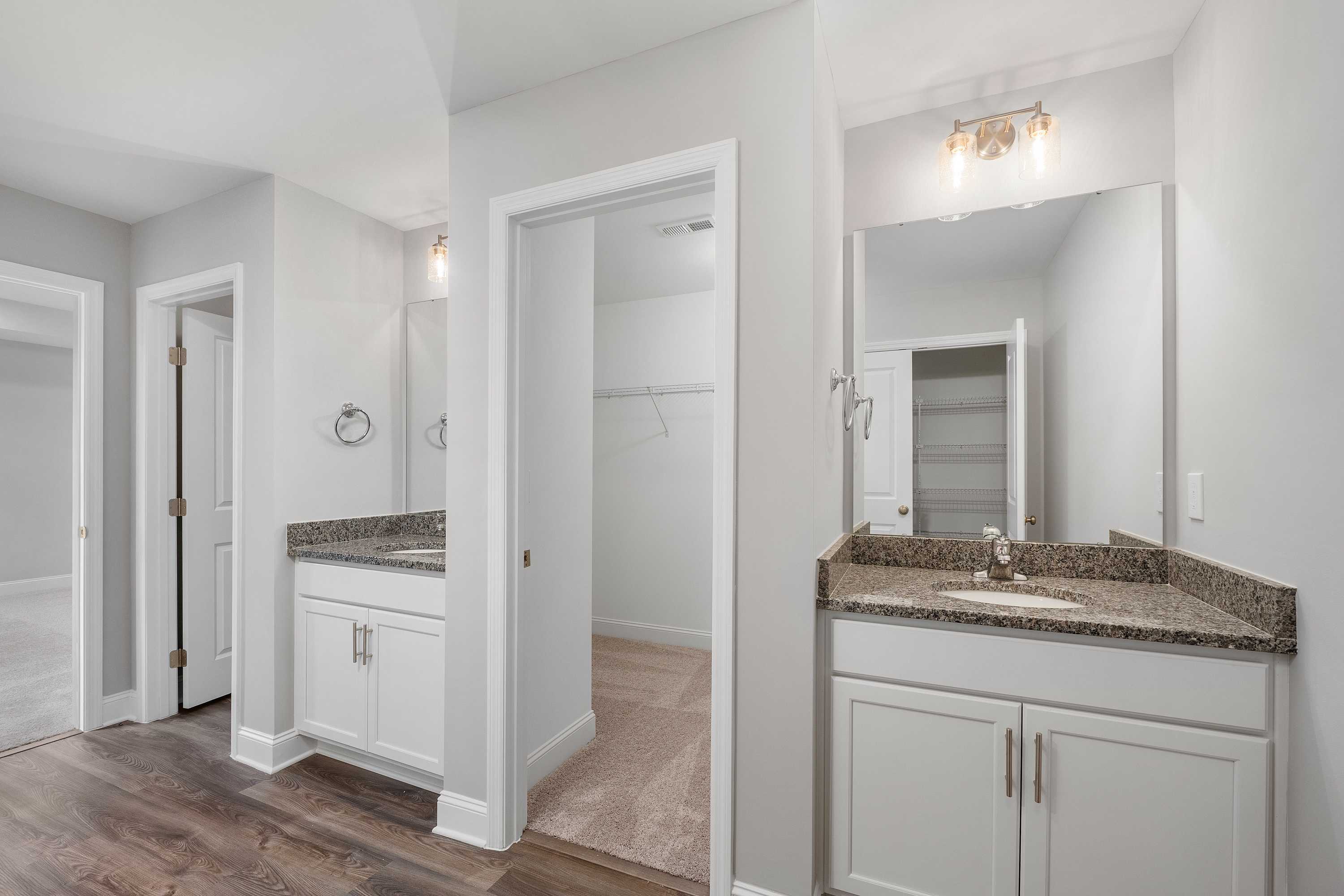 Spacious master bathroom in The Aiken with double vanity, quartz countertop, and adjacent walk-in closet by Davidson Homes