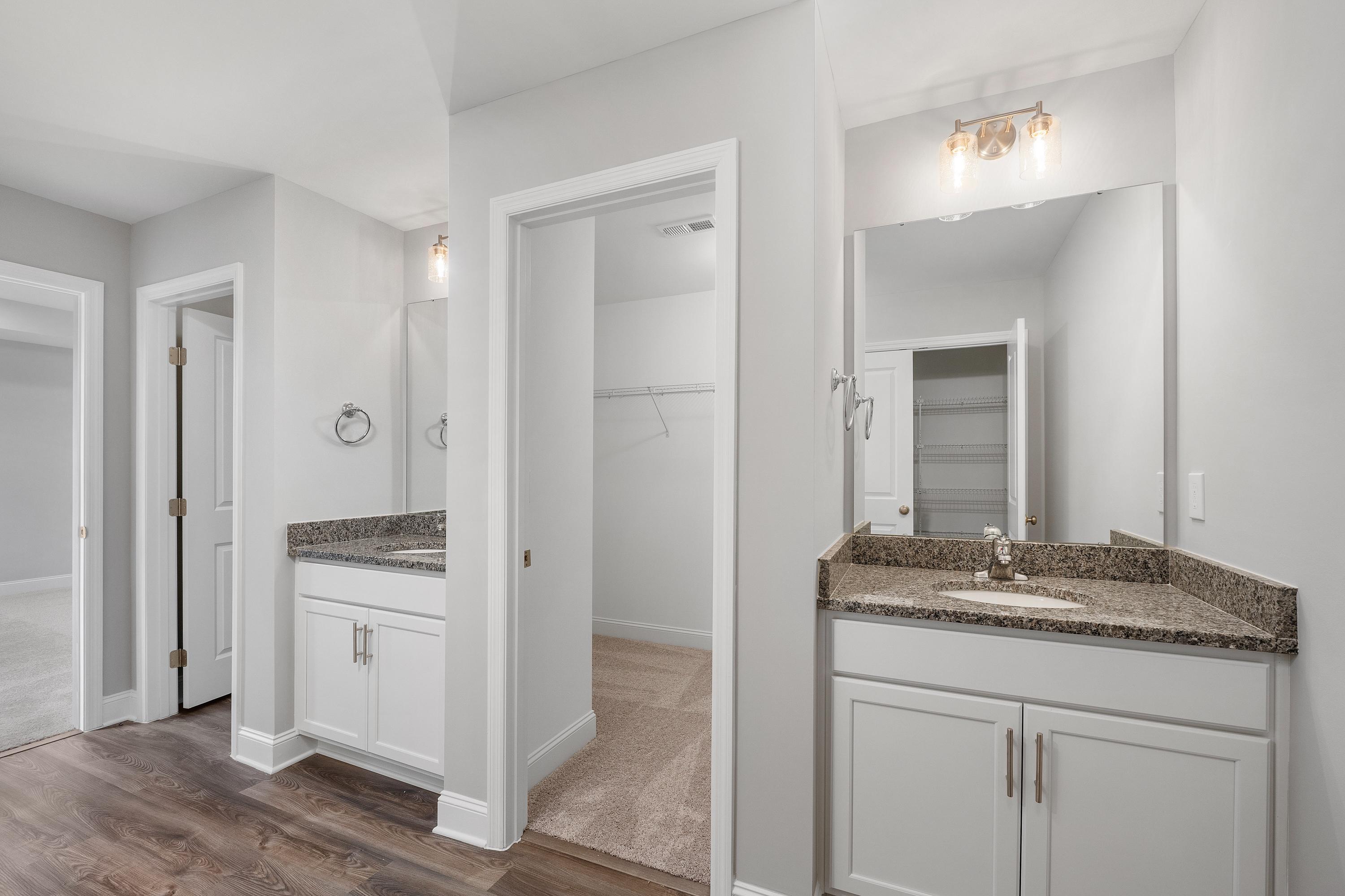 Spacious master bathroom in The Aiken with double vanity, quartz countertop, and adjacent walk-in closet by Davidson Homes