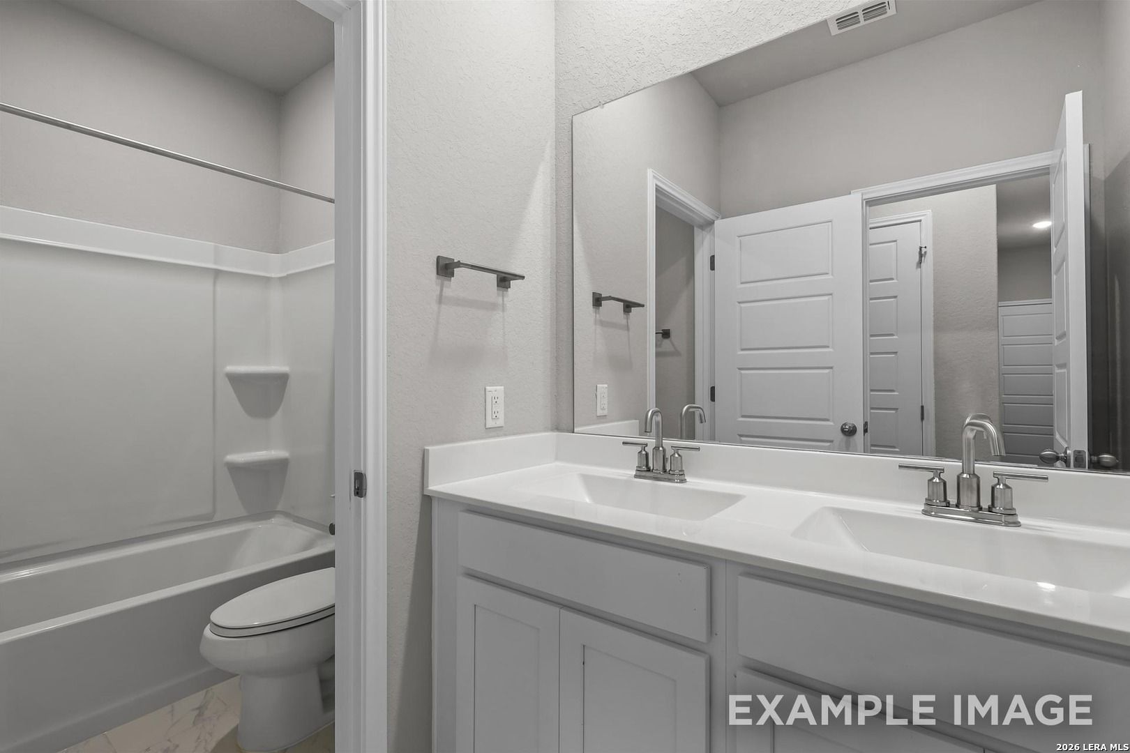 Spacious master bathroom featuring double vanity, tub-shower combo, and large mirror in Davidson Homes The Colorado D, San Antonio, Texas