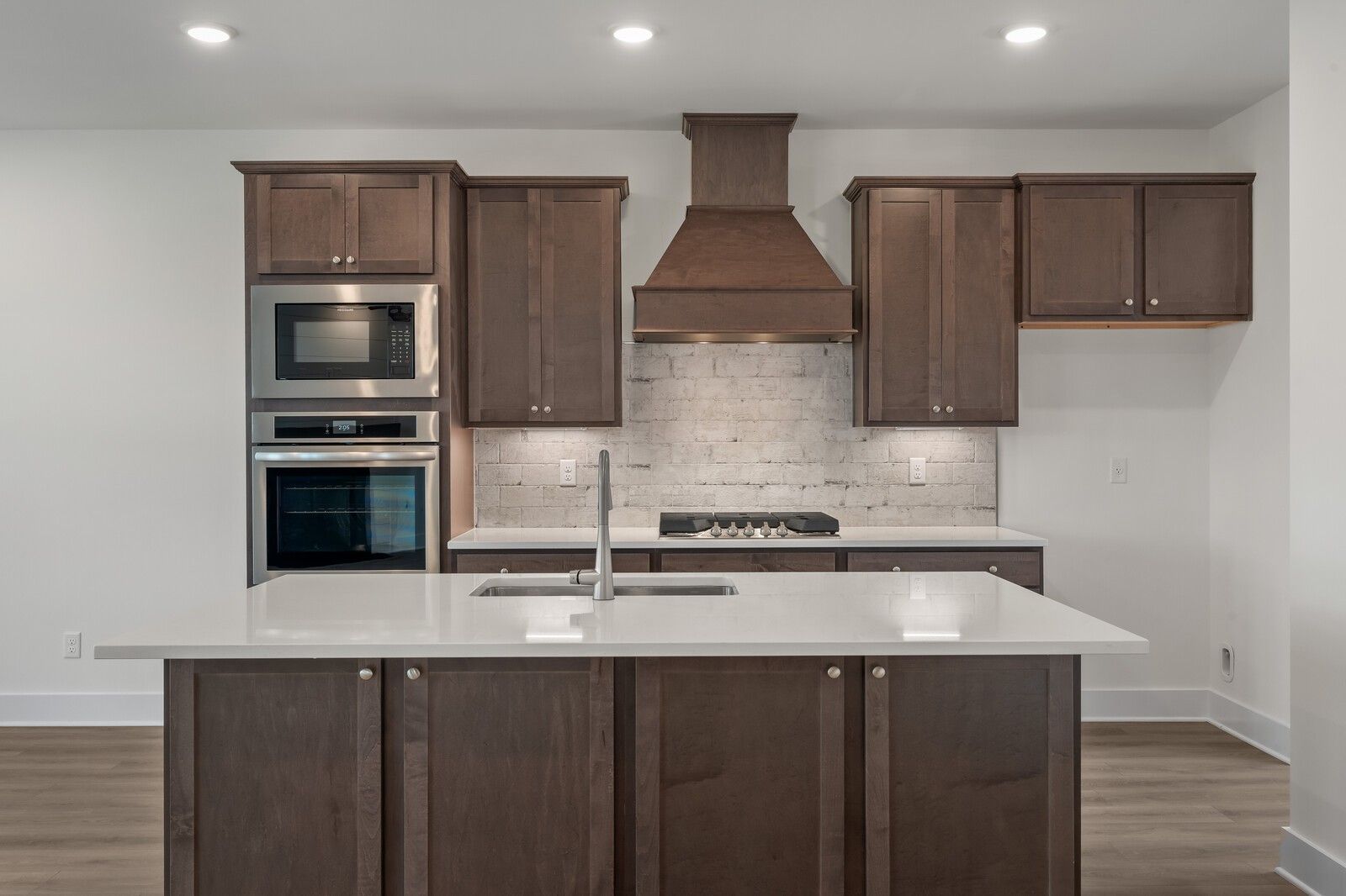 Spacious kitchen with dark shaker cabinets, white quartz island sink, stainless appliances in Davidson Homes The Willow C, Gallatin TN