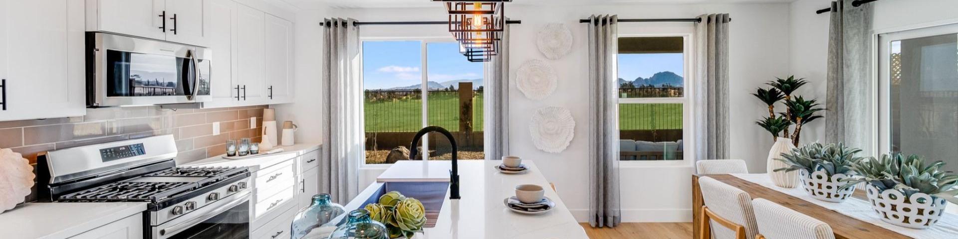 Spacious modern kitchen in South Ranch Southern Collection Prescott AZ with white quartz island, stainless appliances, pendant lighting and desert views