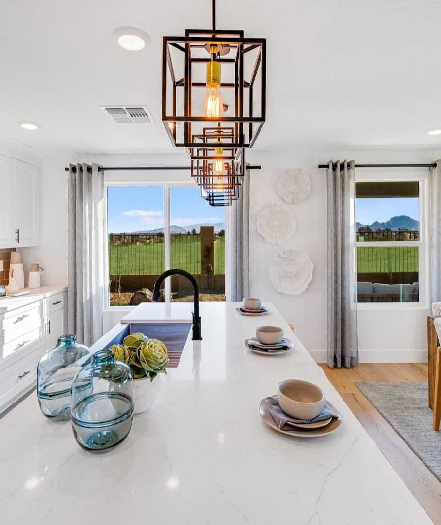 Spacious modern kitchen in South Ranch Southern Collection Prescott AZ with white quartz island, stainless appliances, pendant lighting and desert views