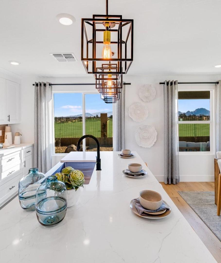 Spacious modern kitchen in South Ranch Southern Collection Prescott AZ with white quartz island, stainless appliances, pendant lighting and desert views