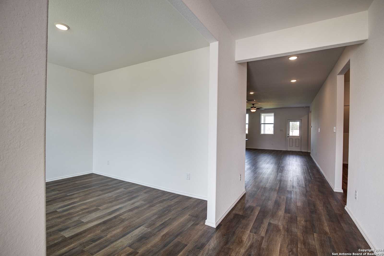 Spacious open hallway with laminate wood flooring and recessed lights in Davidson Homes The Douglas D, Seguin, Texas