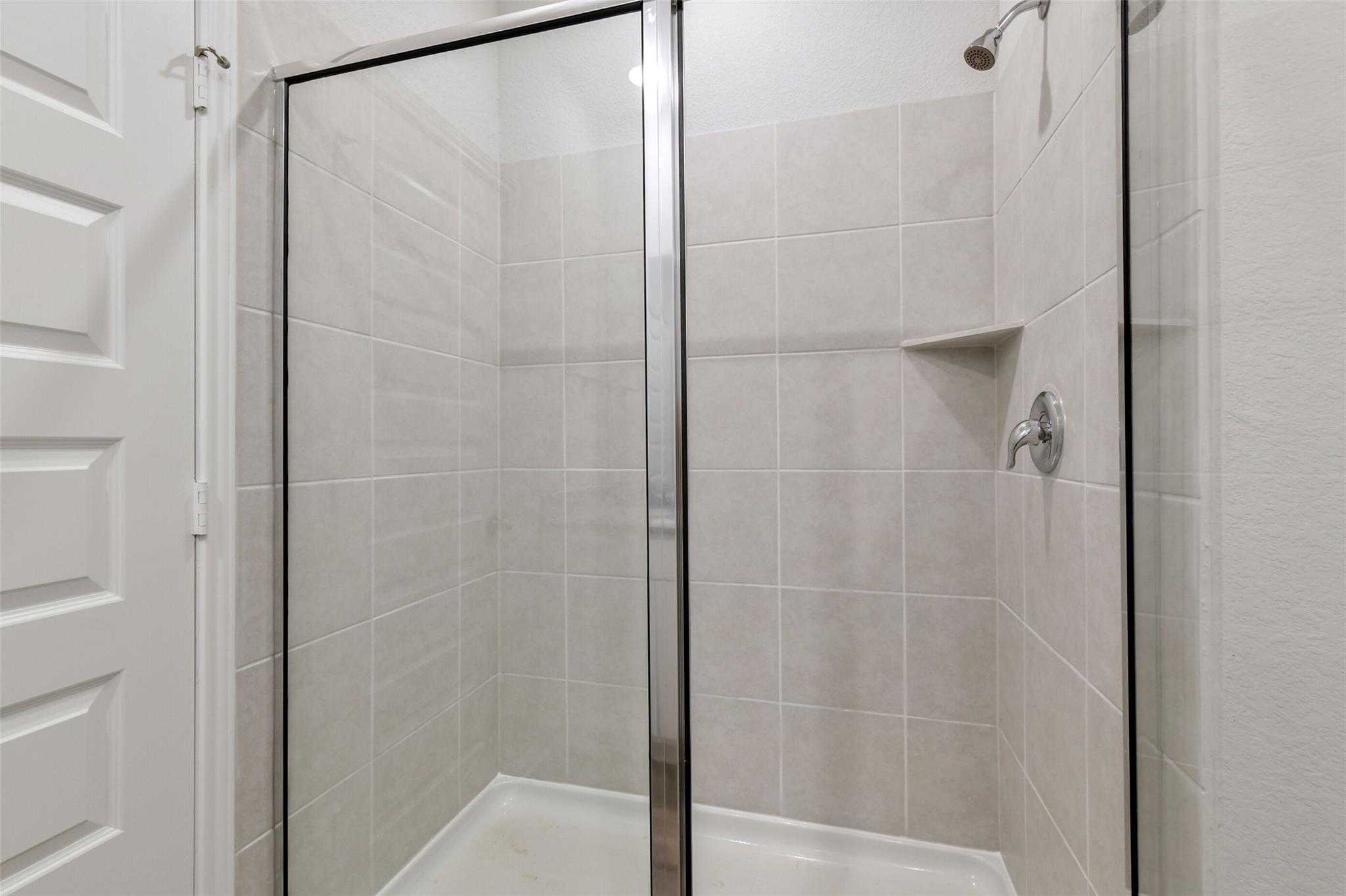 Modern walk-in shower with frameless glass doors and subway tile walls in master bath, The Frio G by Davidson Homes, Conroe TX