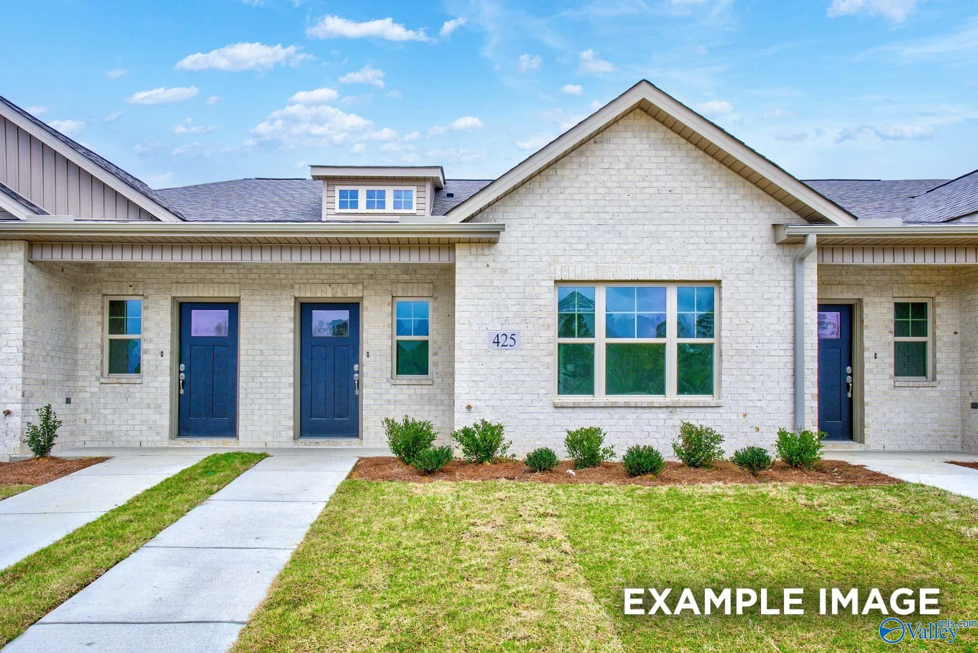 Modern white brick single-story home with blue doors, large windows, and address 425 in The Retreat at Cain Park, Hartselle, Alabama