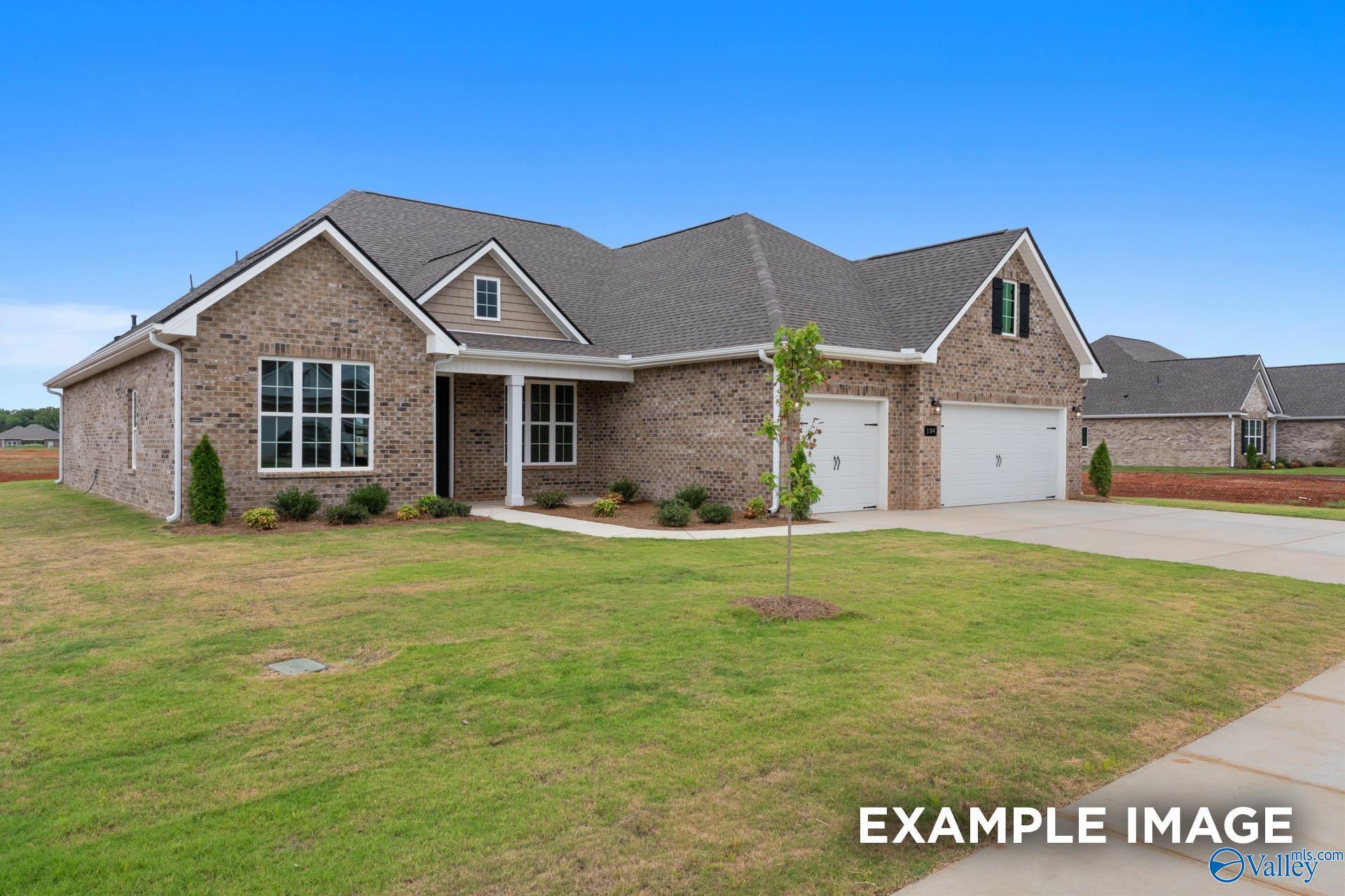 Brick single-story 3-bedroom home with 2-car garage, gabled roof, and landscaped lawn in Creekside, Harvest, Alabama
