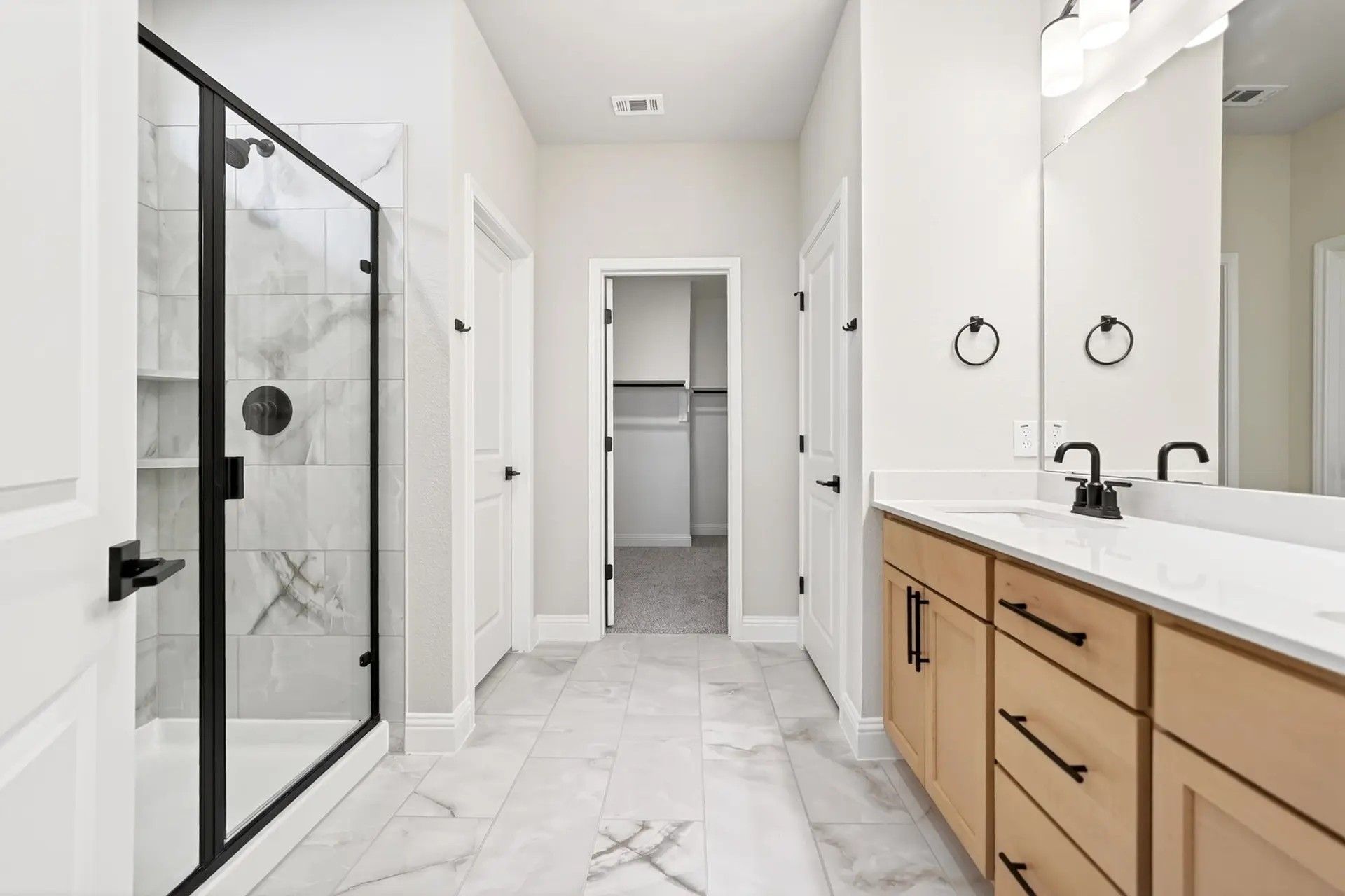 Modern bathroom with walk-in shower and dual vanity in The Holly C floor plan by Davidson Homes in Heartland, Texas.
