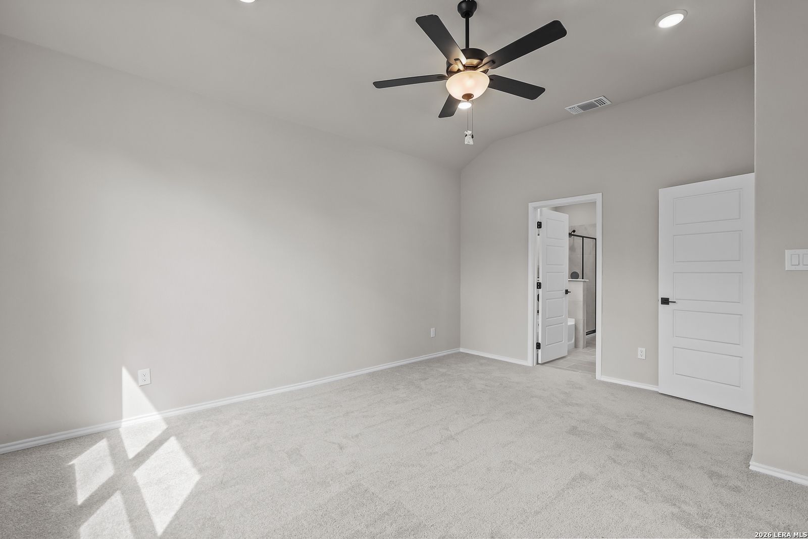 Spacious carpeted bedroom with ceiling fan and en suite bath access in Davidson Homes Sequoia C plan, Royal Crest, San Antonio