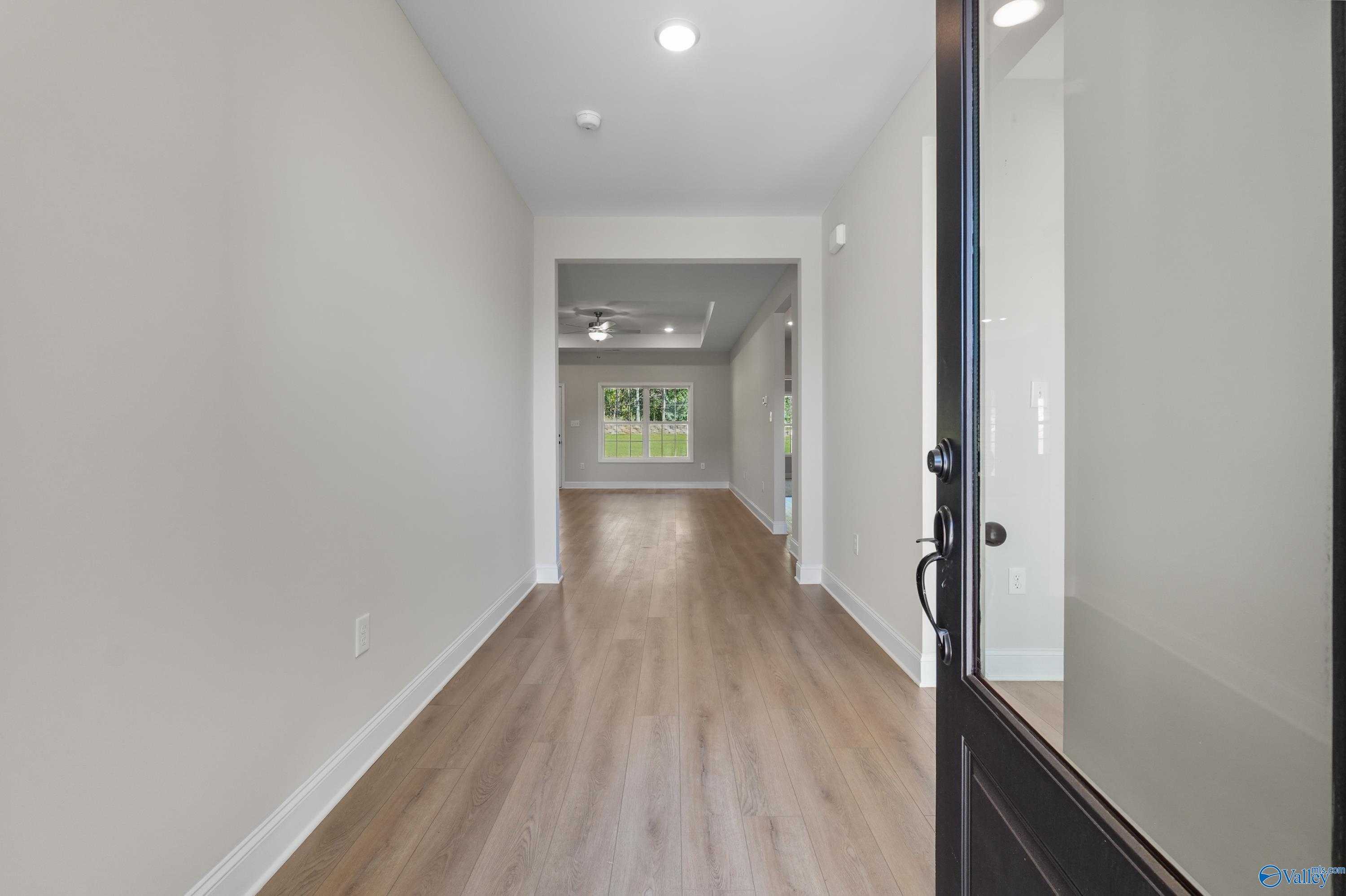 Spacious entry hallway with light hardwood floors and neutral walls in Davidson Homes The Montgomery C, Decatur, Alabama
