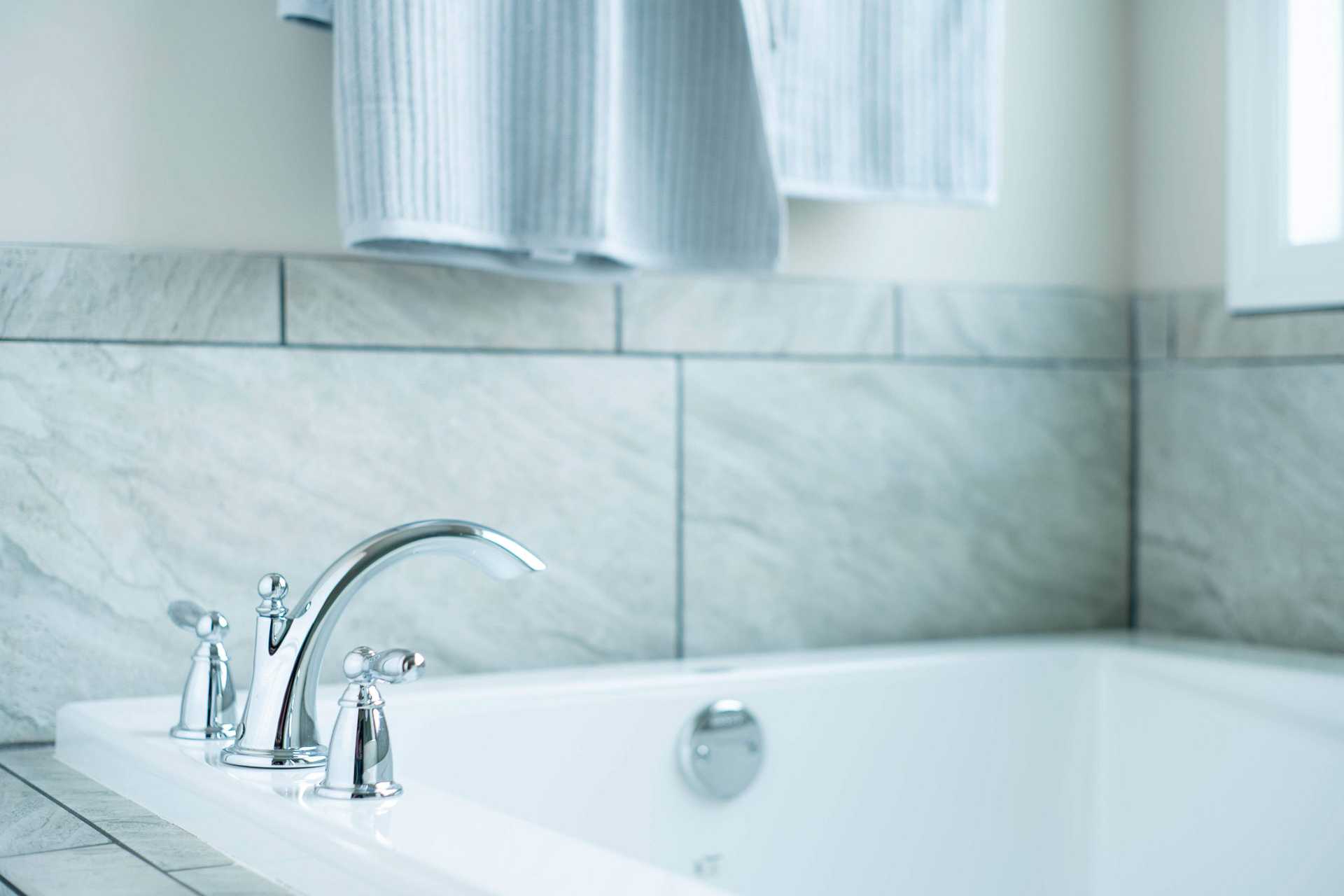 Freestanding bathtub with chrome faucets in luxurious bathroom at The Dairy at Oak Grove, South Huntsville AL by Davidson Homes