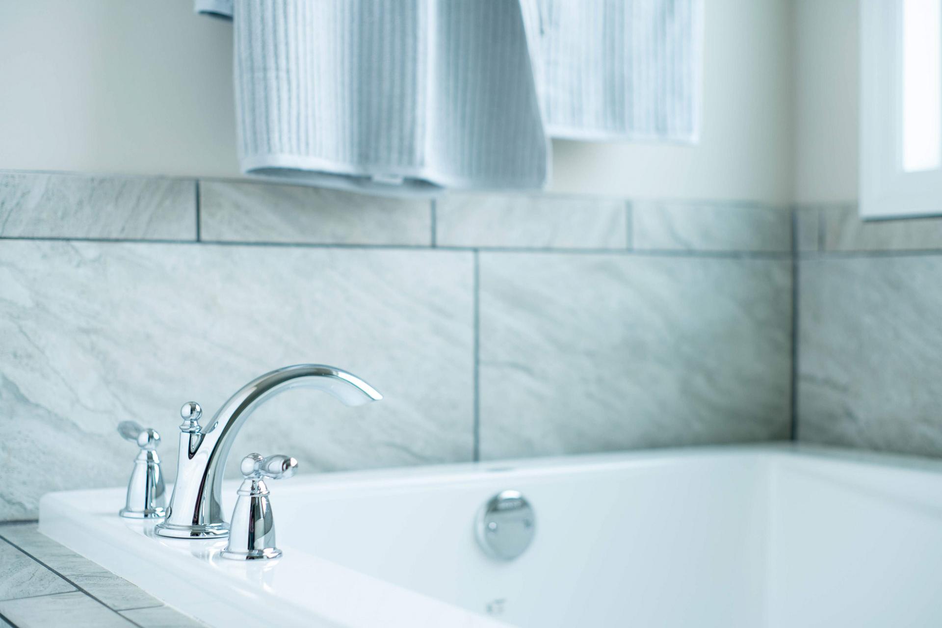 Freestanding bathtub with chrome faucets in luxurious bathroom at The Dairy at Oak Grove, South Huntsville AL by Davidson Homes
