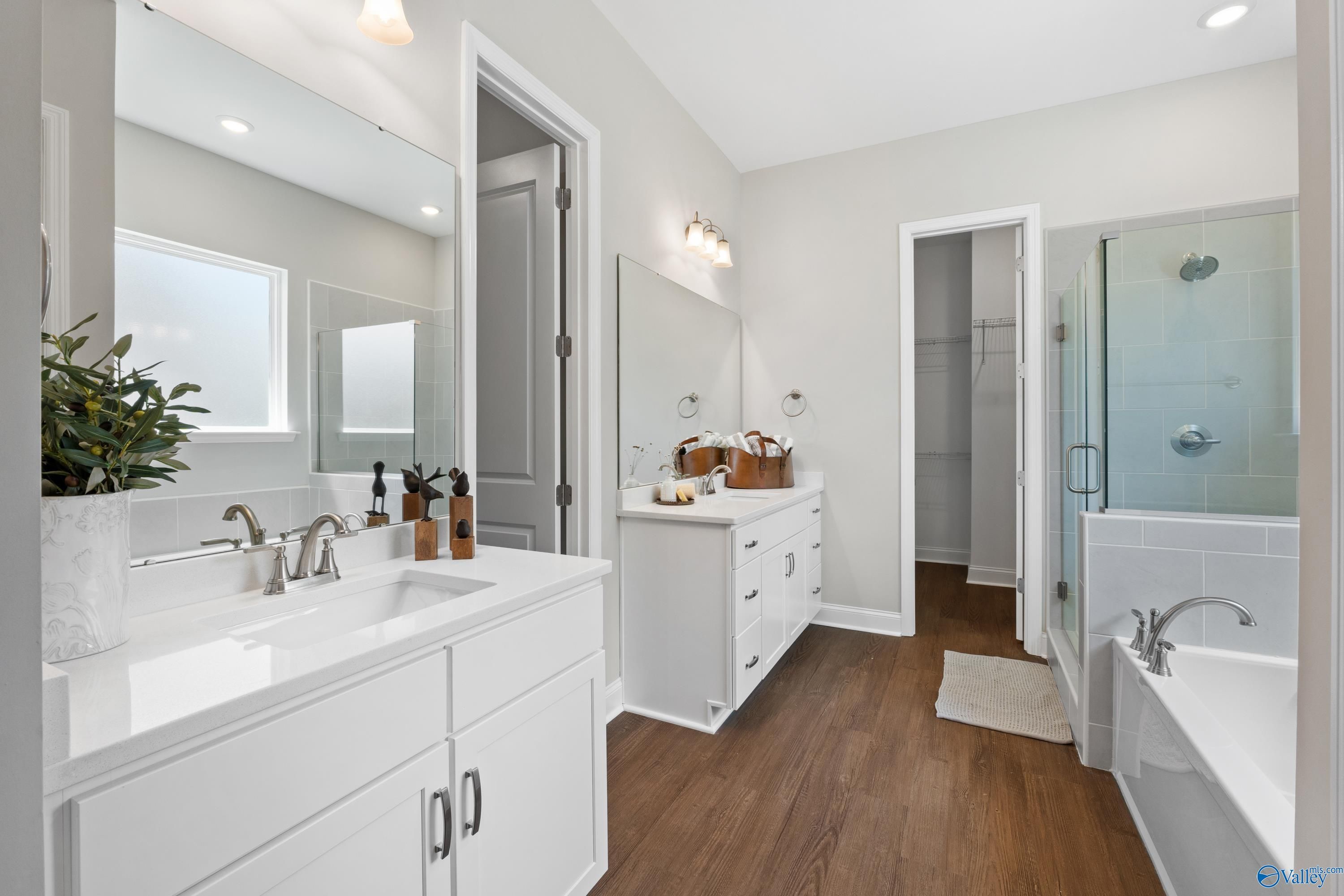 Elegant master bathroom with double white vanity, glass shower enclosure, and freestanding tub in Evermore Homes The Haven, Owens Cross Roads, Alabama